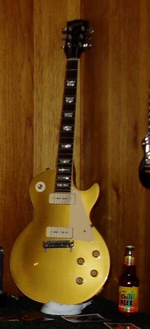 Picture of Les Paul brand electric guitar. there is a bottle in lower right hand cornere that says "Chili Beer".