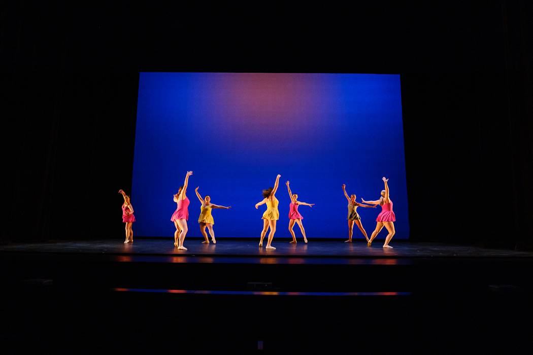 Dancers on stage in colorful costumes at Texas State University