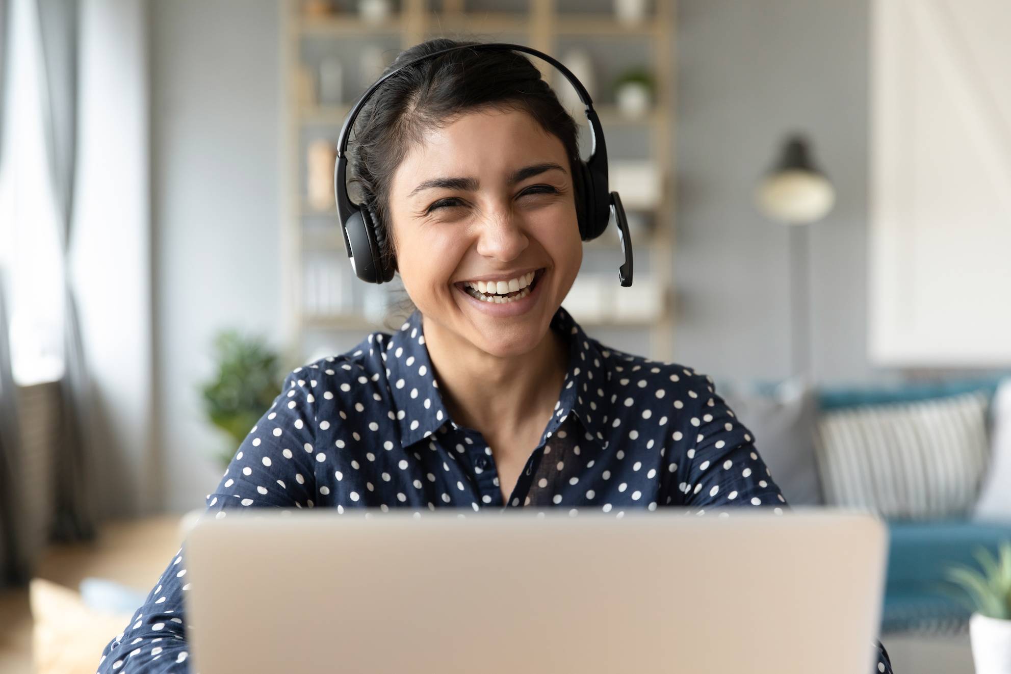 Person with headset on sitting in front of laptop