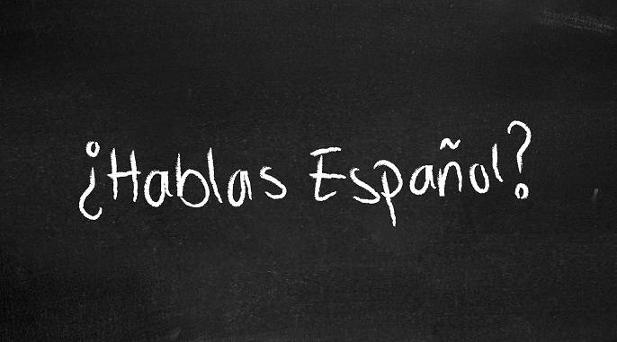 "Hablas Espanol" written on a chalk board.