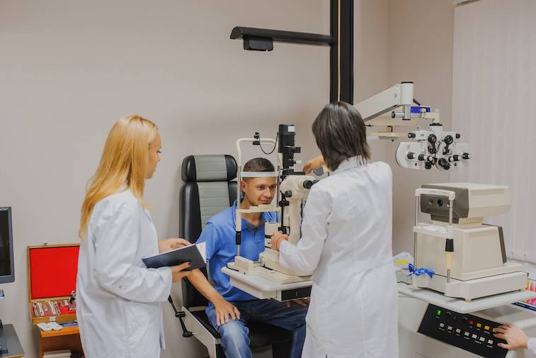 Optometry students working with a patient in an office