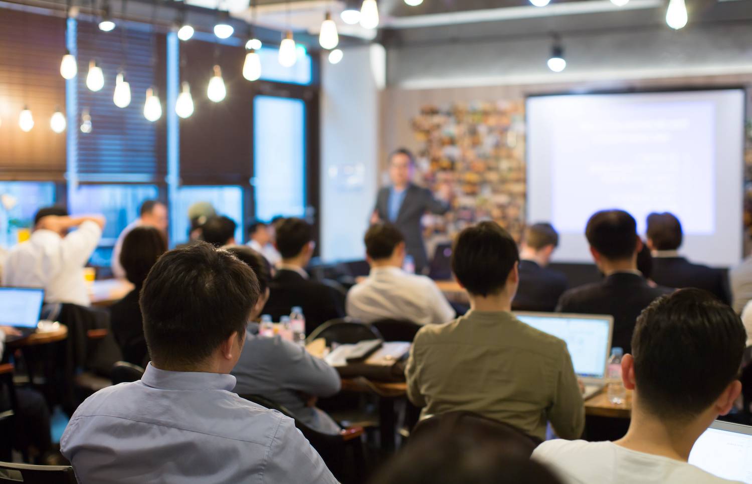 students seated in a classroom facing a projector screen