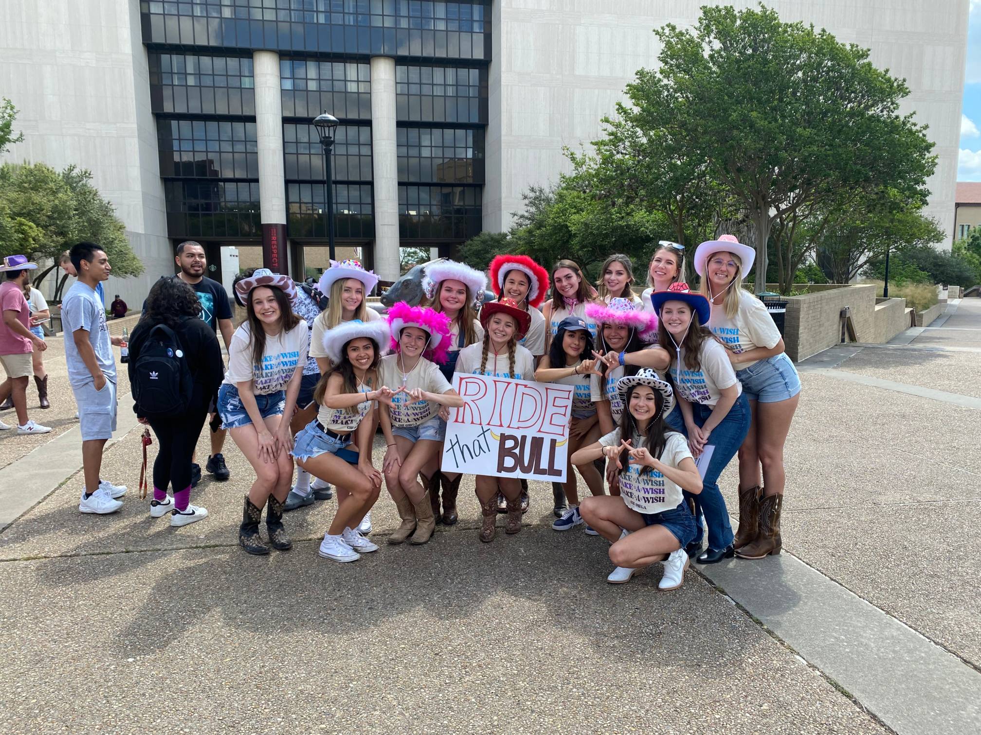 Students posing in the LBJ Mall wearing decorated cowboy hats