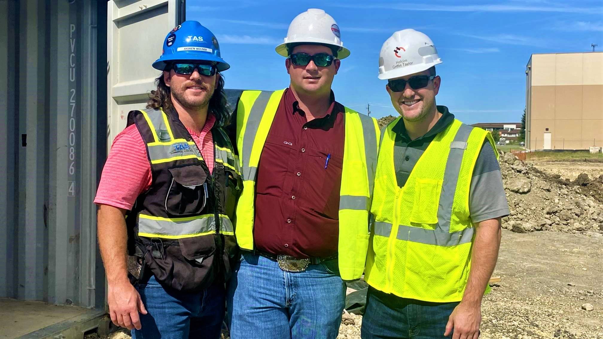 three engineering technology majors wearing hardhats on construction site