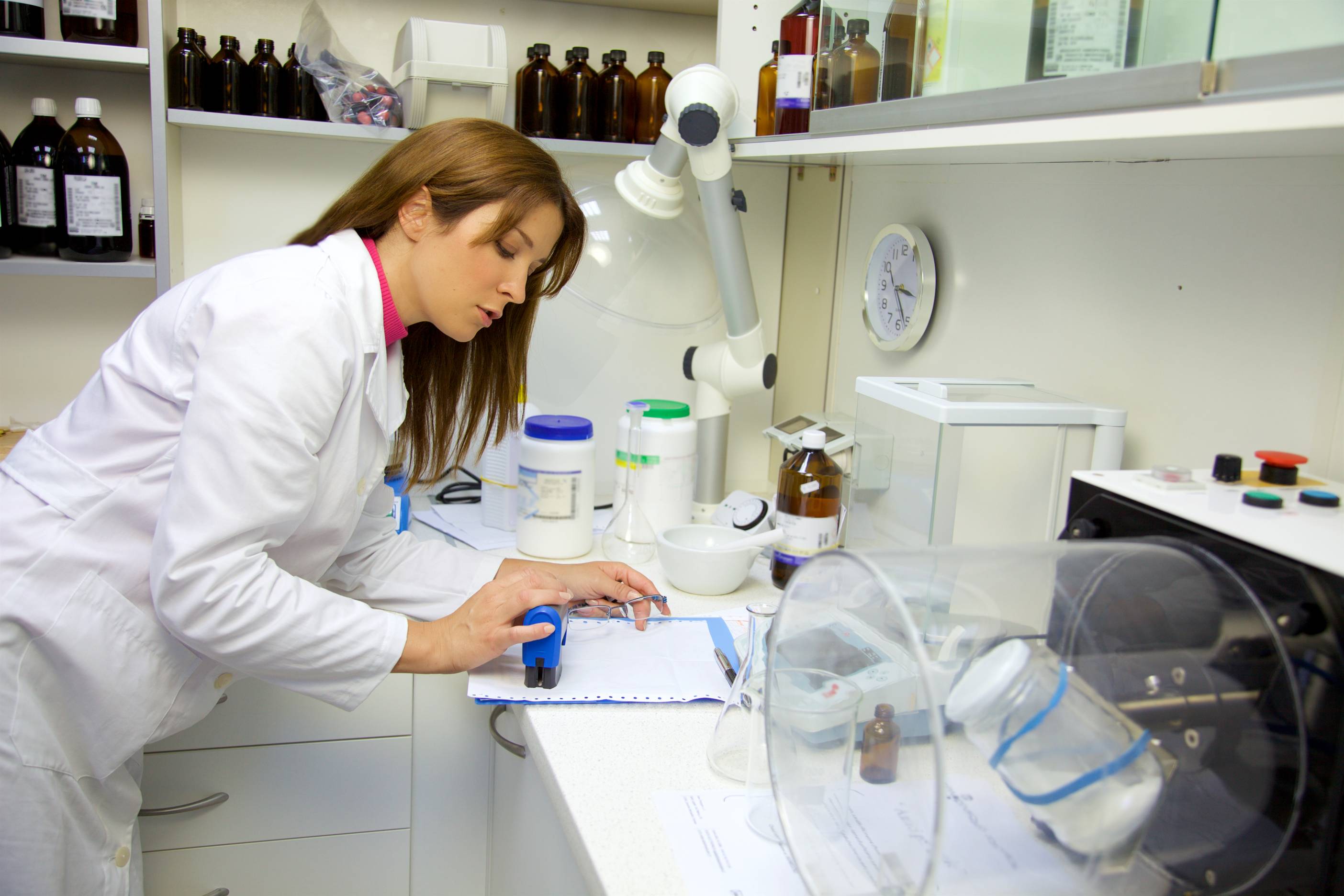 female pharmaceutical scientist doing calculations in laboratory