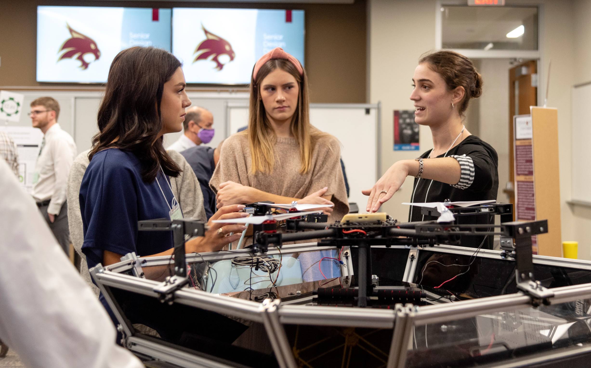 three female engineering students discussing a senior design engineering project