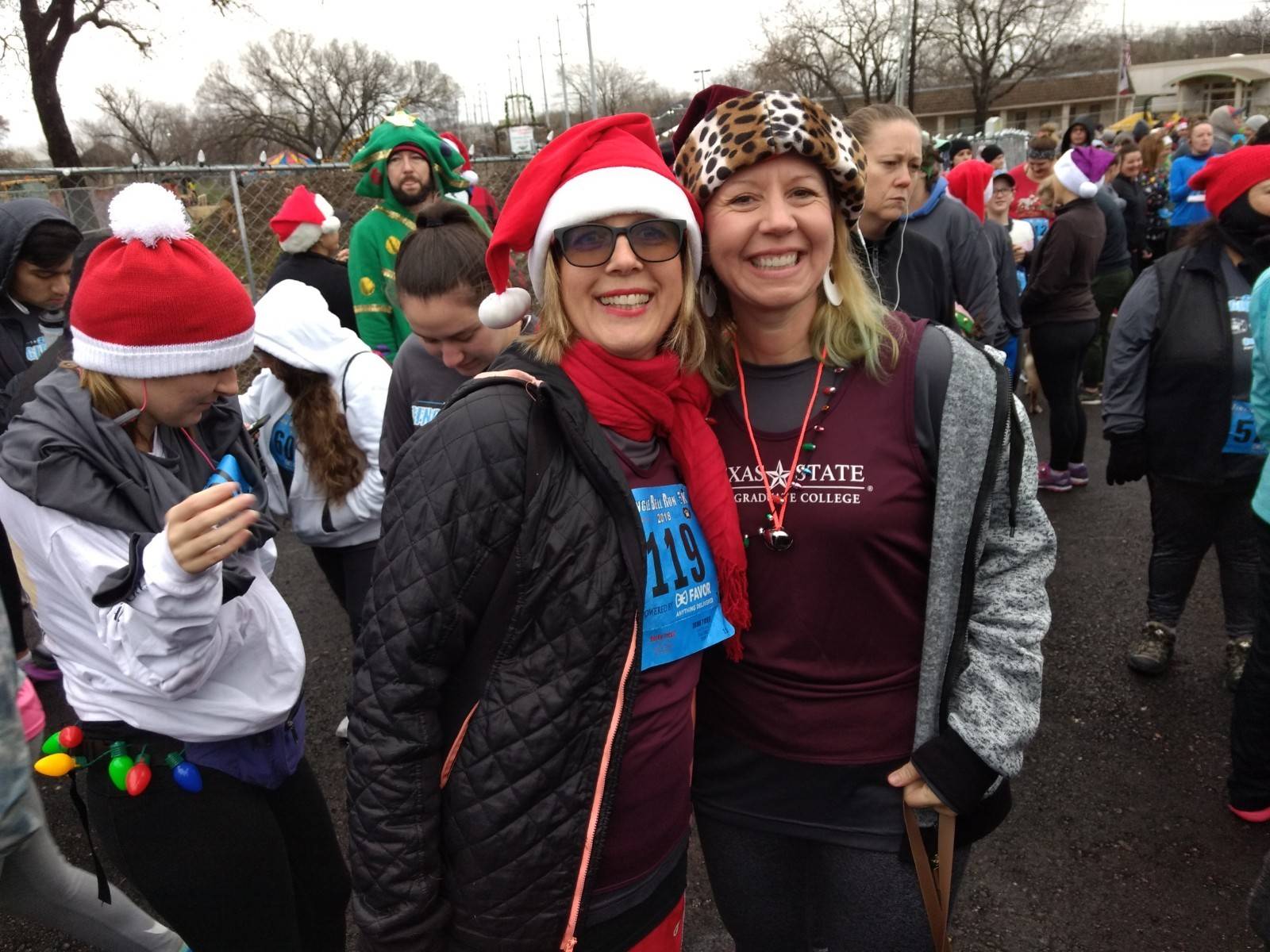 two runners wearing the Running With the Graduate Deans shirt and christmas hats