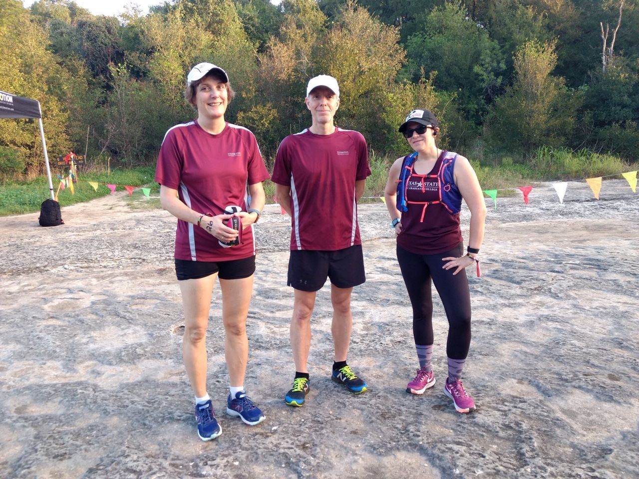 Dr. Andrea Golato, Dr. Eric Paulson, and another runner standing in front of trees, ready to run