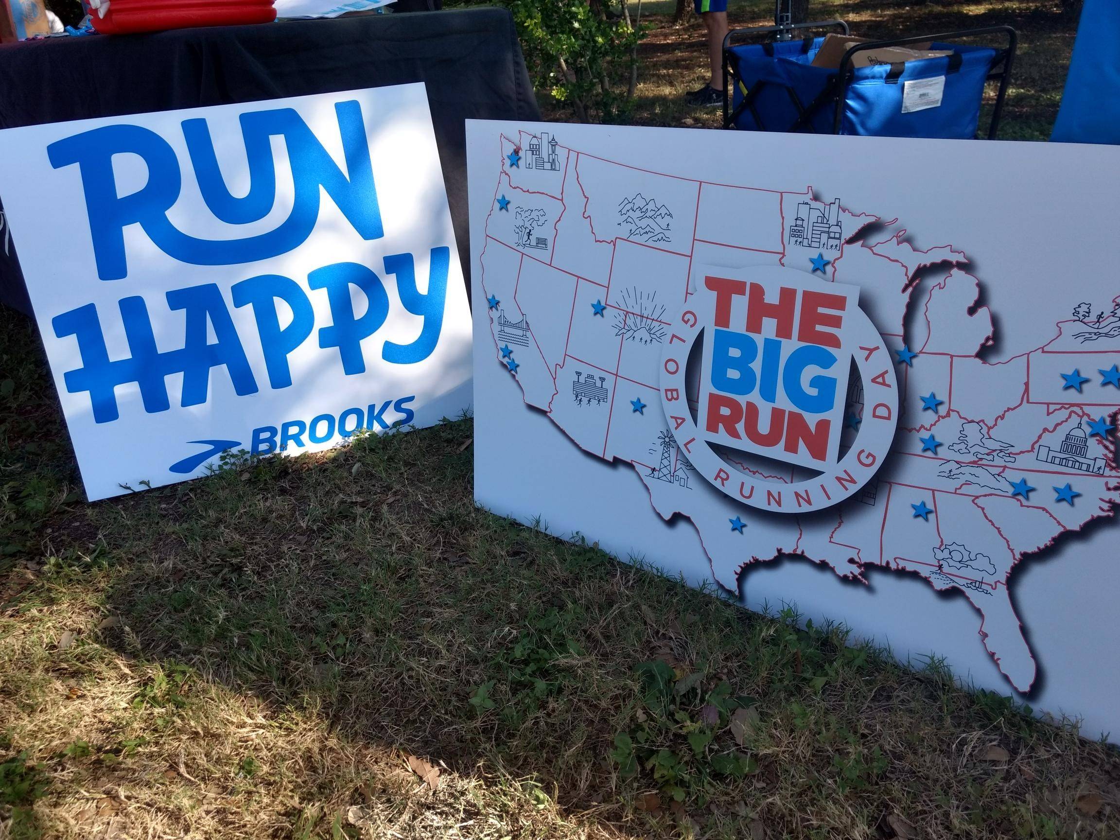 Two signs: "Run Happy" and a map of the United States with "The Big Run" logo