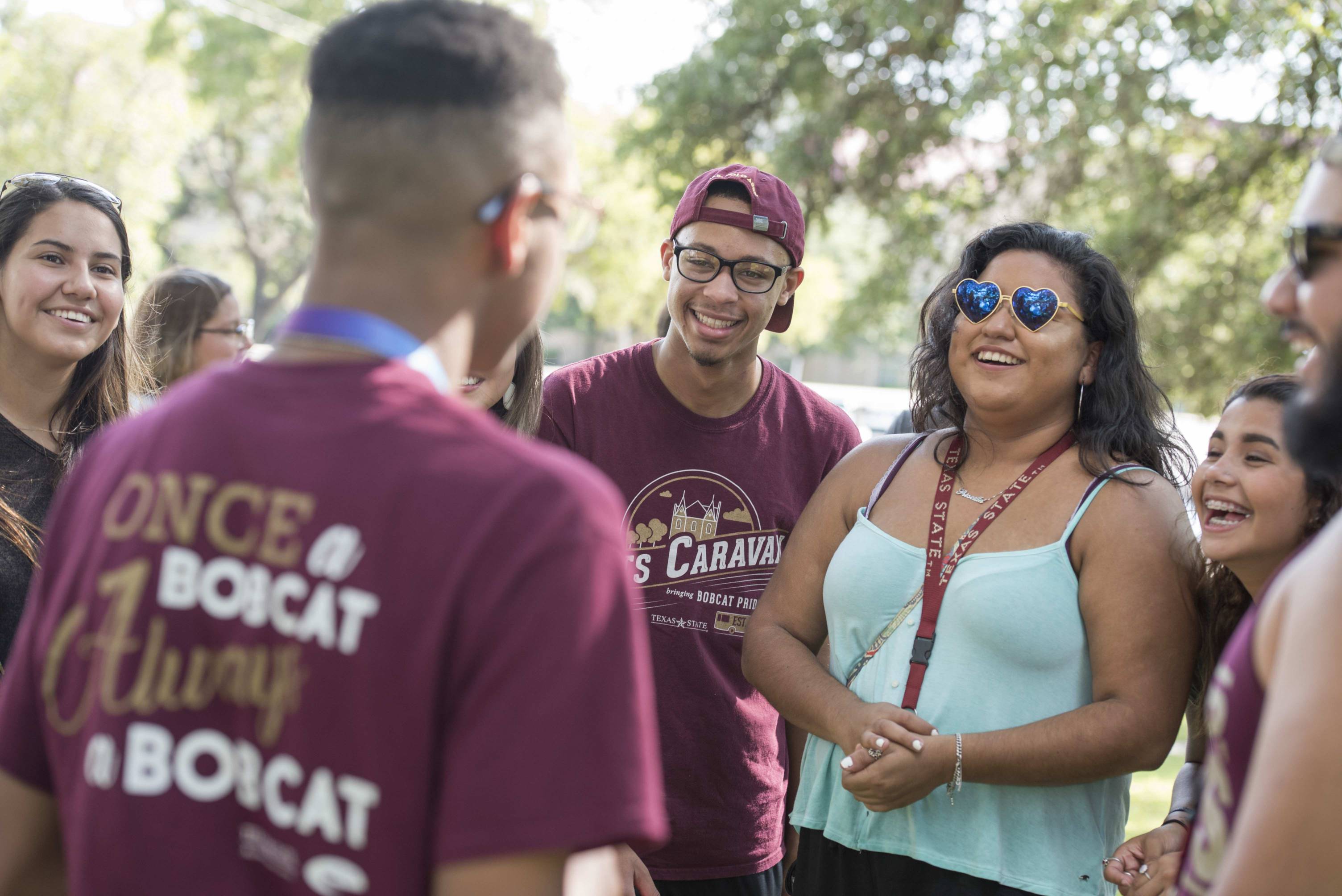 a group of students in texas state attire and gear smile
