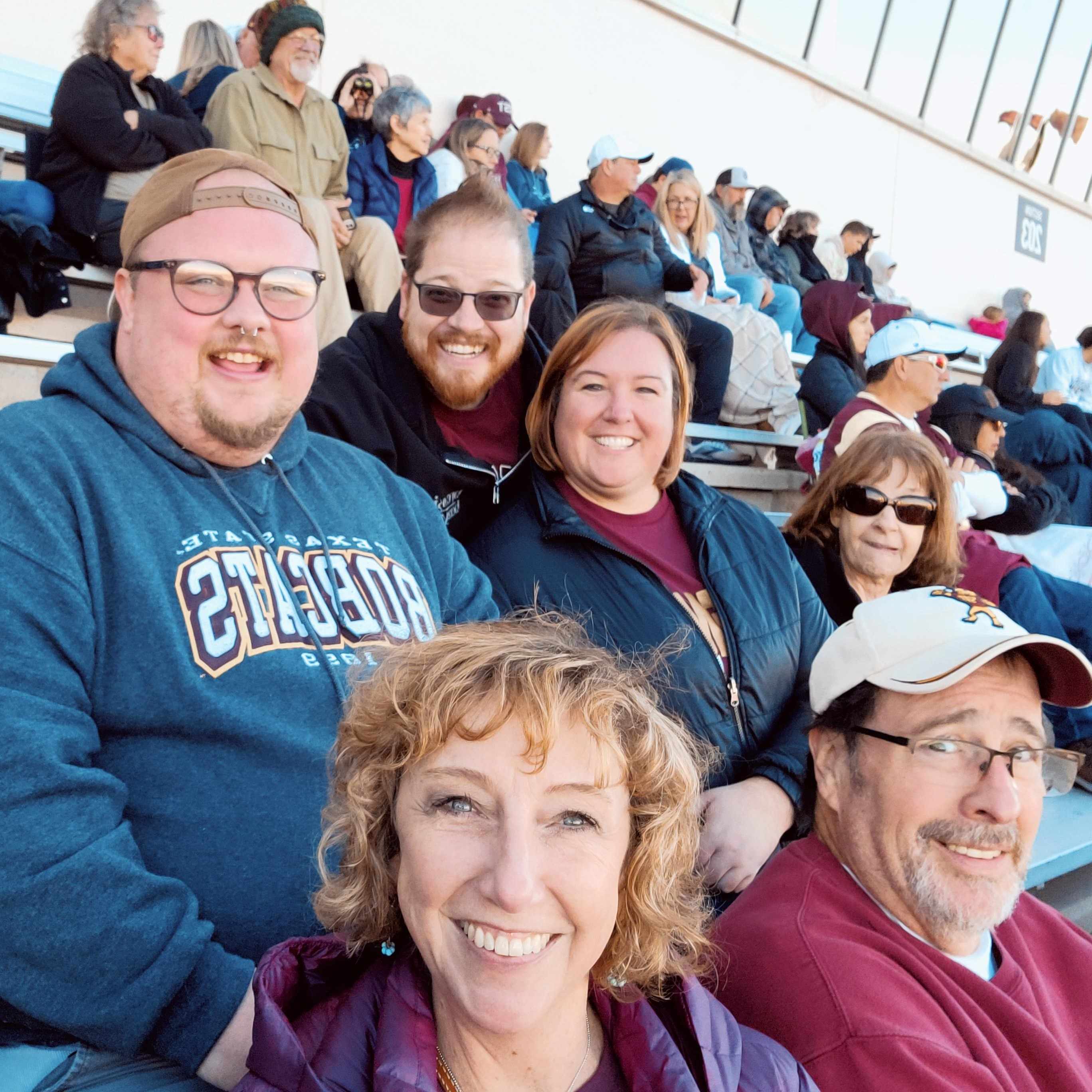 Members of The Graduate College cheering for Mark Moore in the football stands