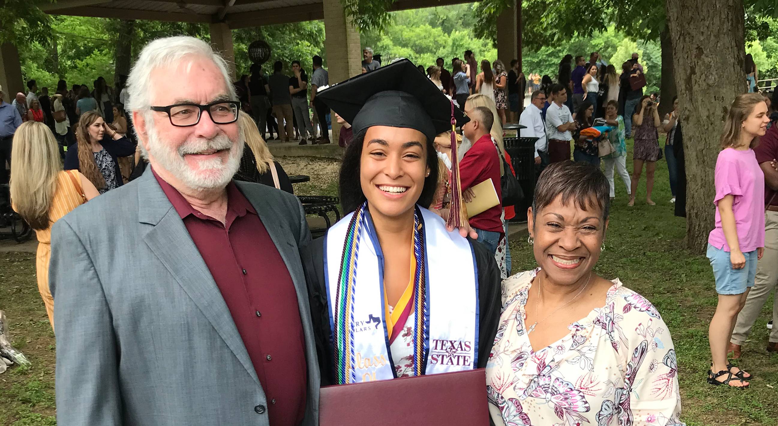 graduate with parents smiling