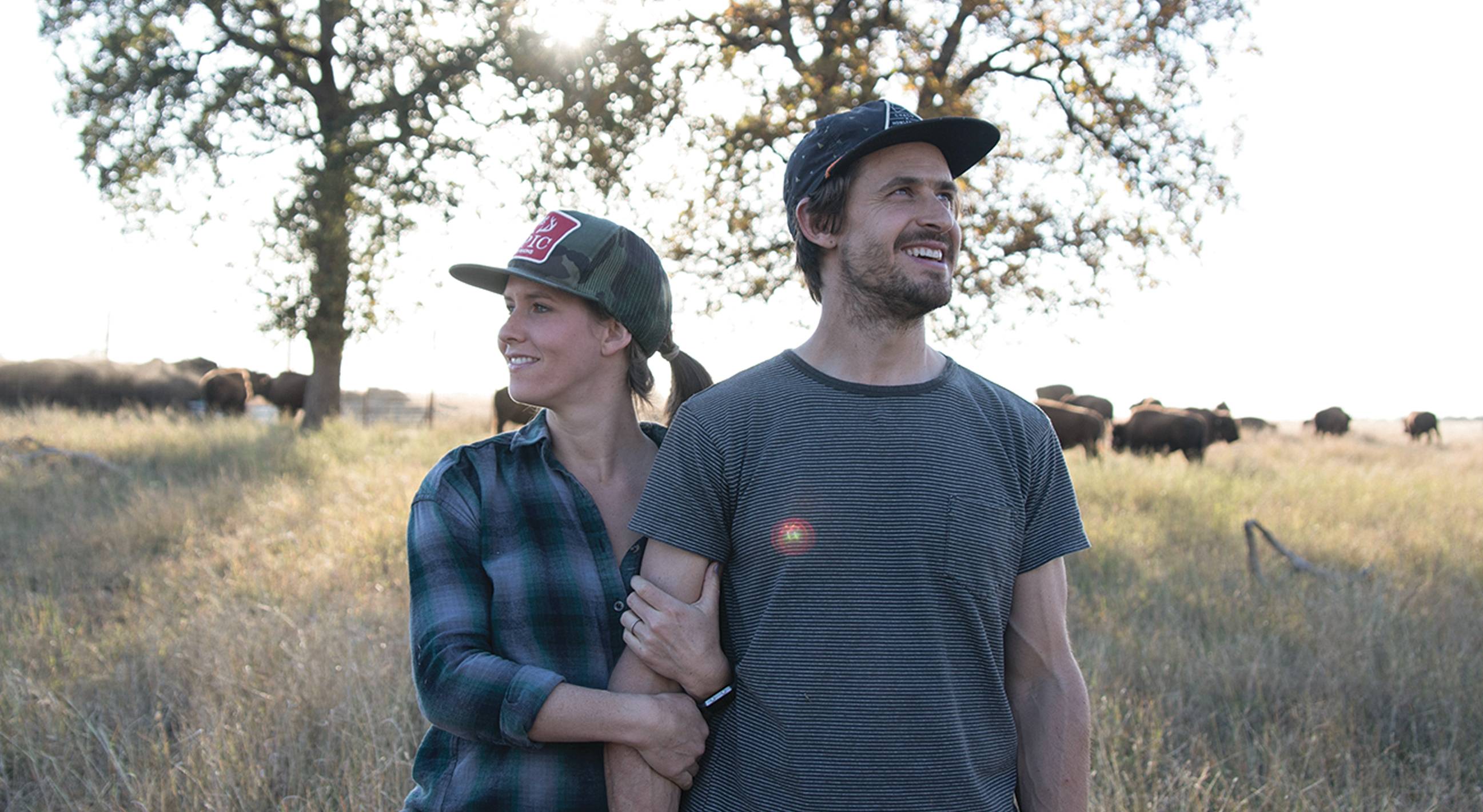 Katie forrest and taylor collins in field with bison