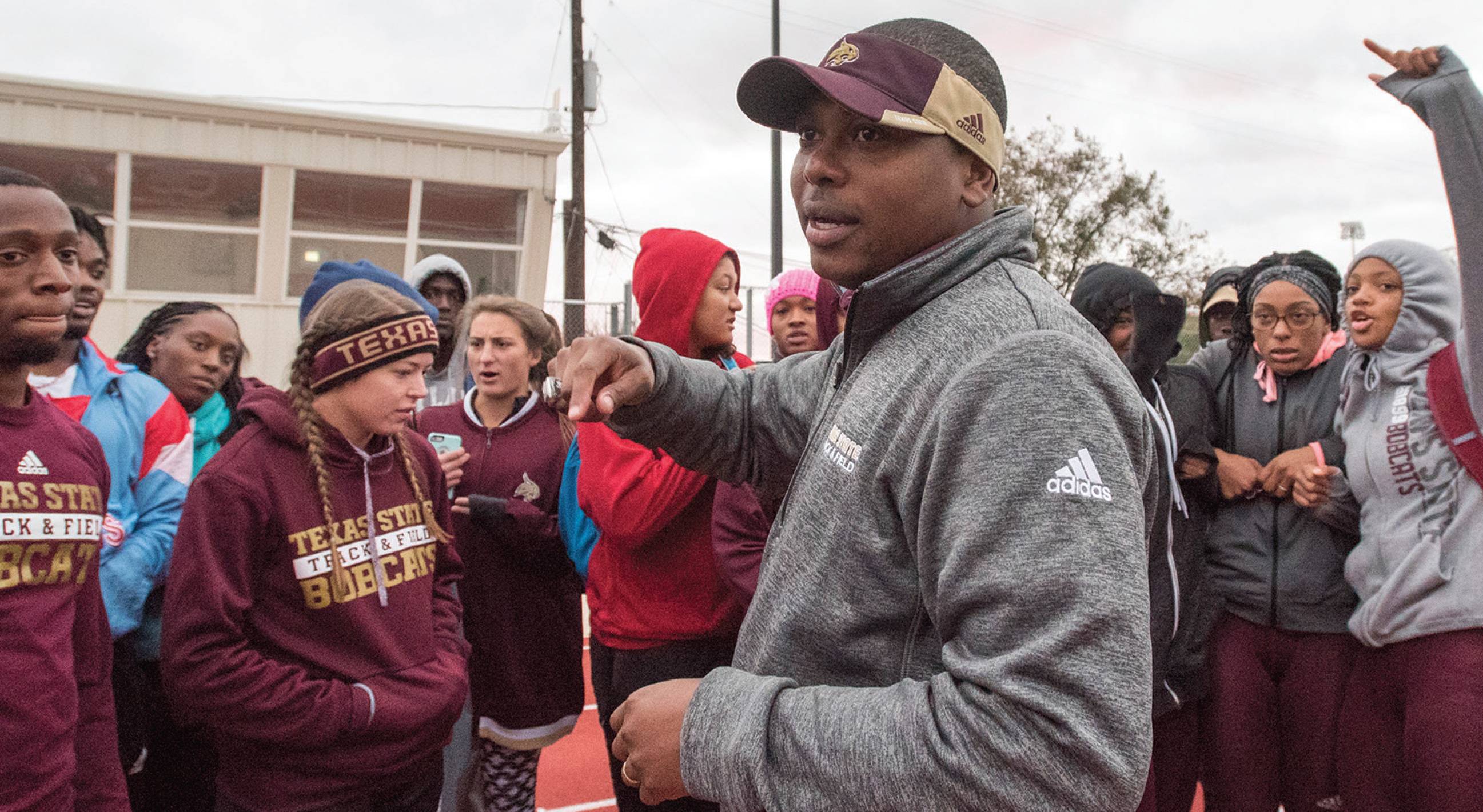 Coach Stewart talks to a crowd of students