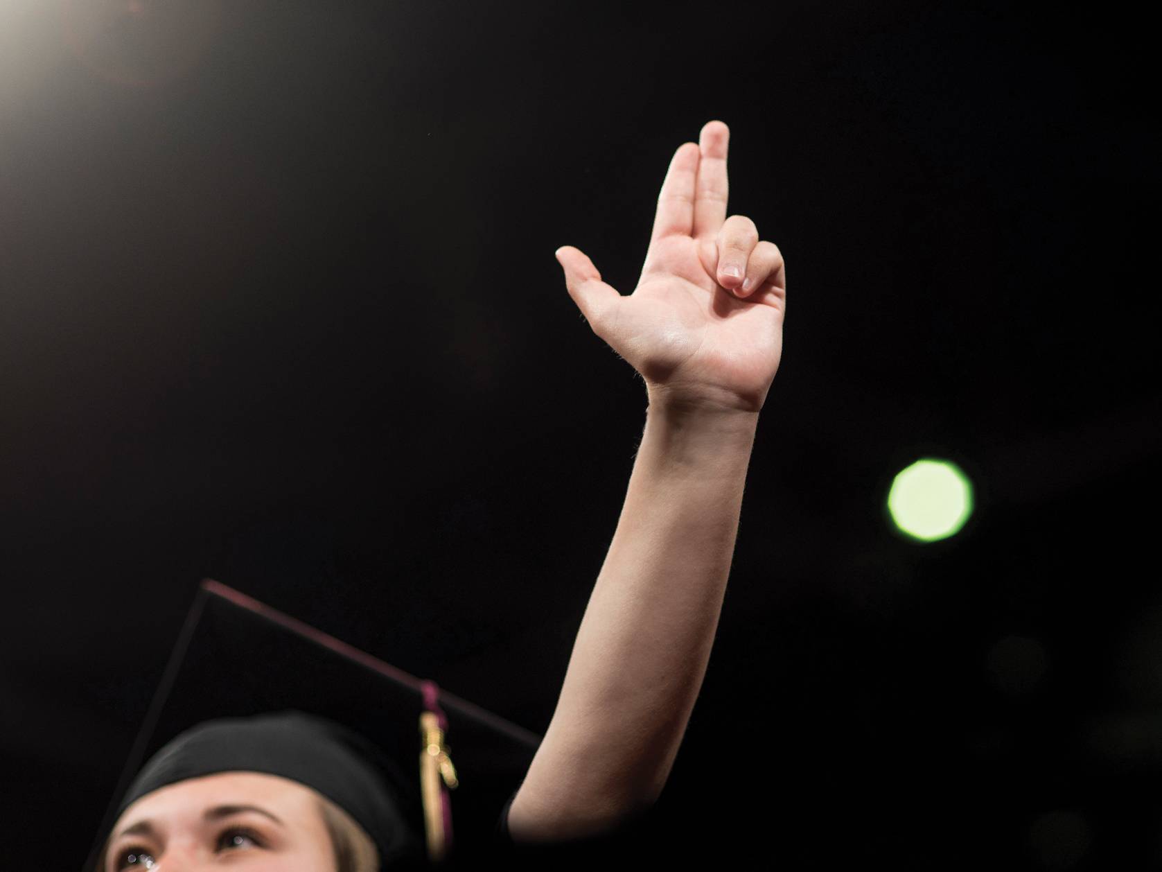 graduate holding up texas state hand sign