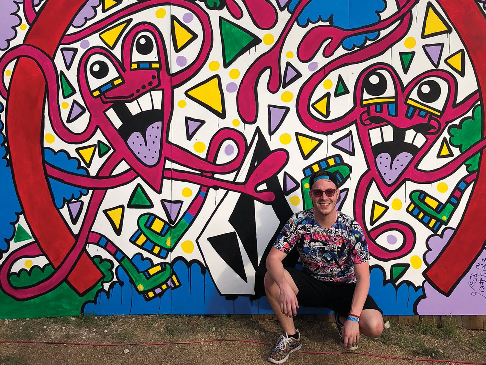 man sitting in front of graffiti wall