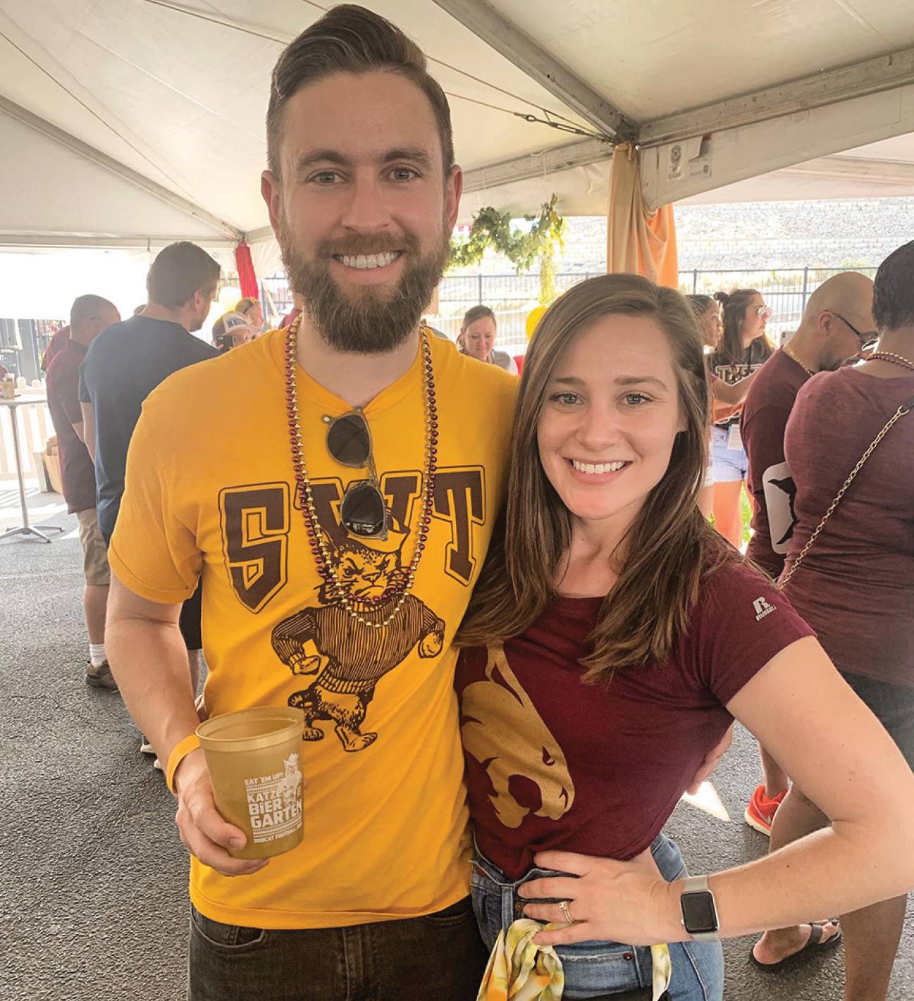 young couple smiling at tailgate