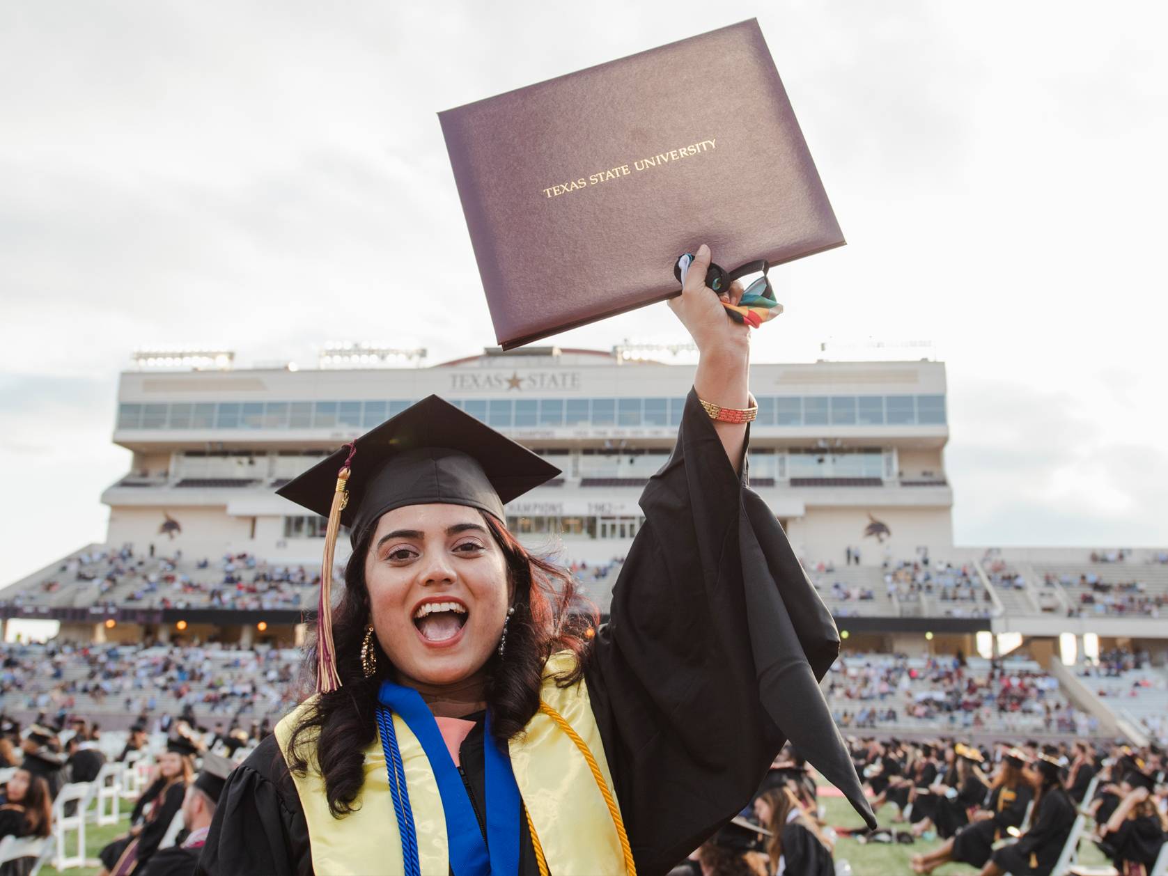 woman holding up diploma