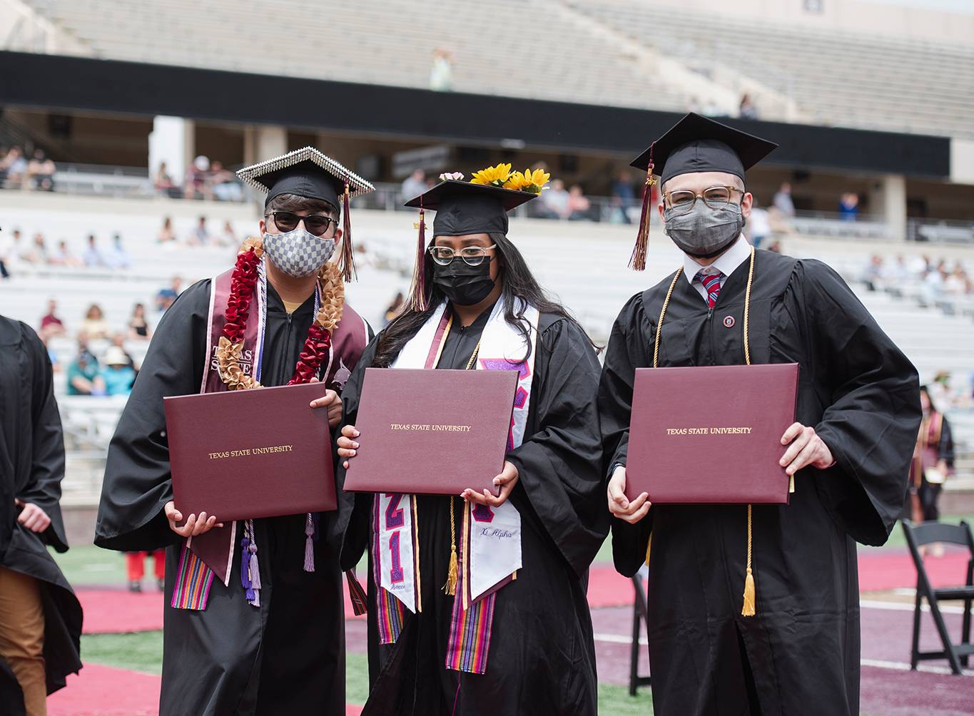 3 people holding diplomas