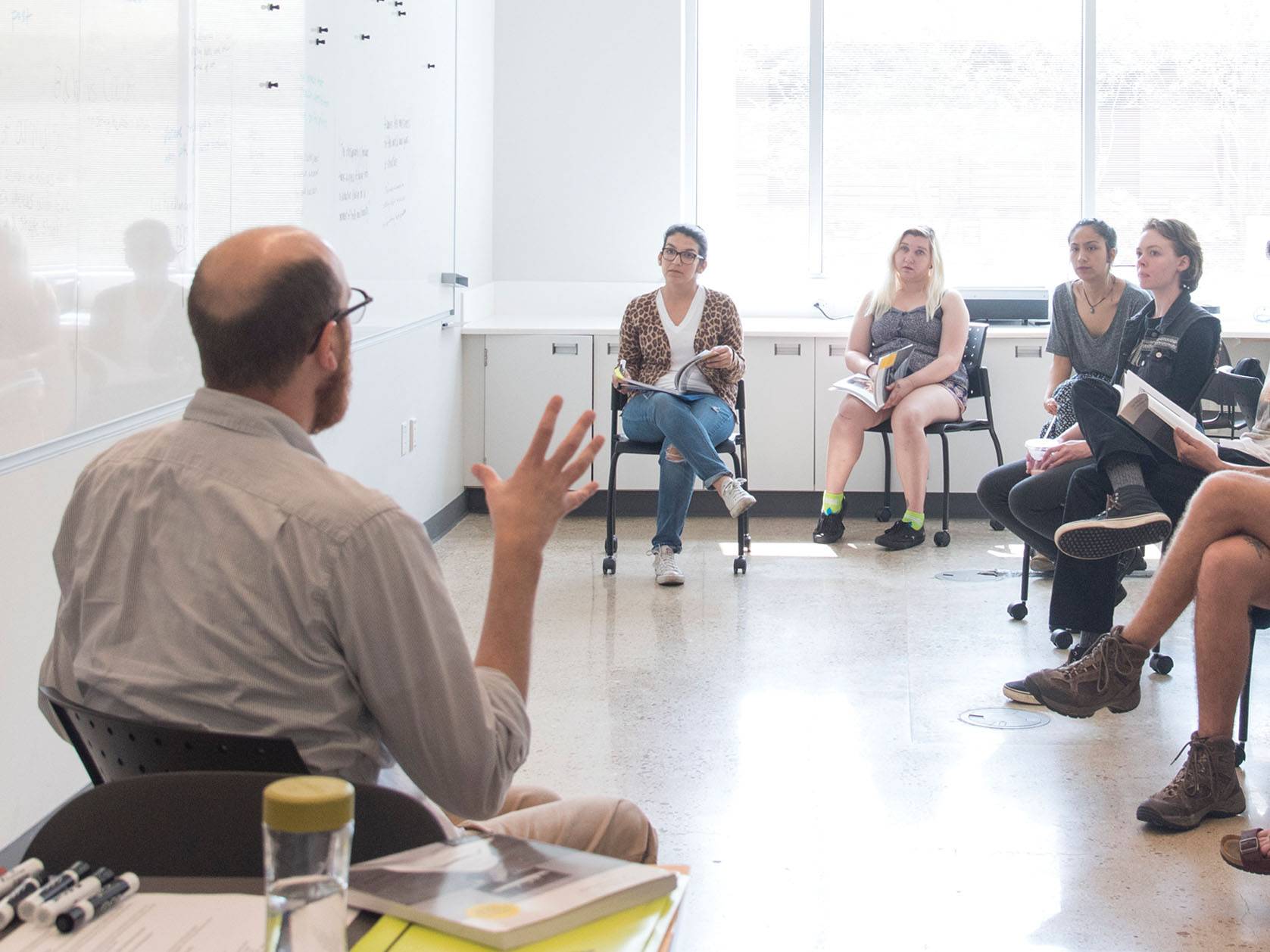 professor talking to group of students in classroom