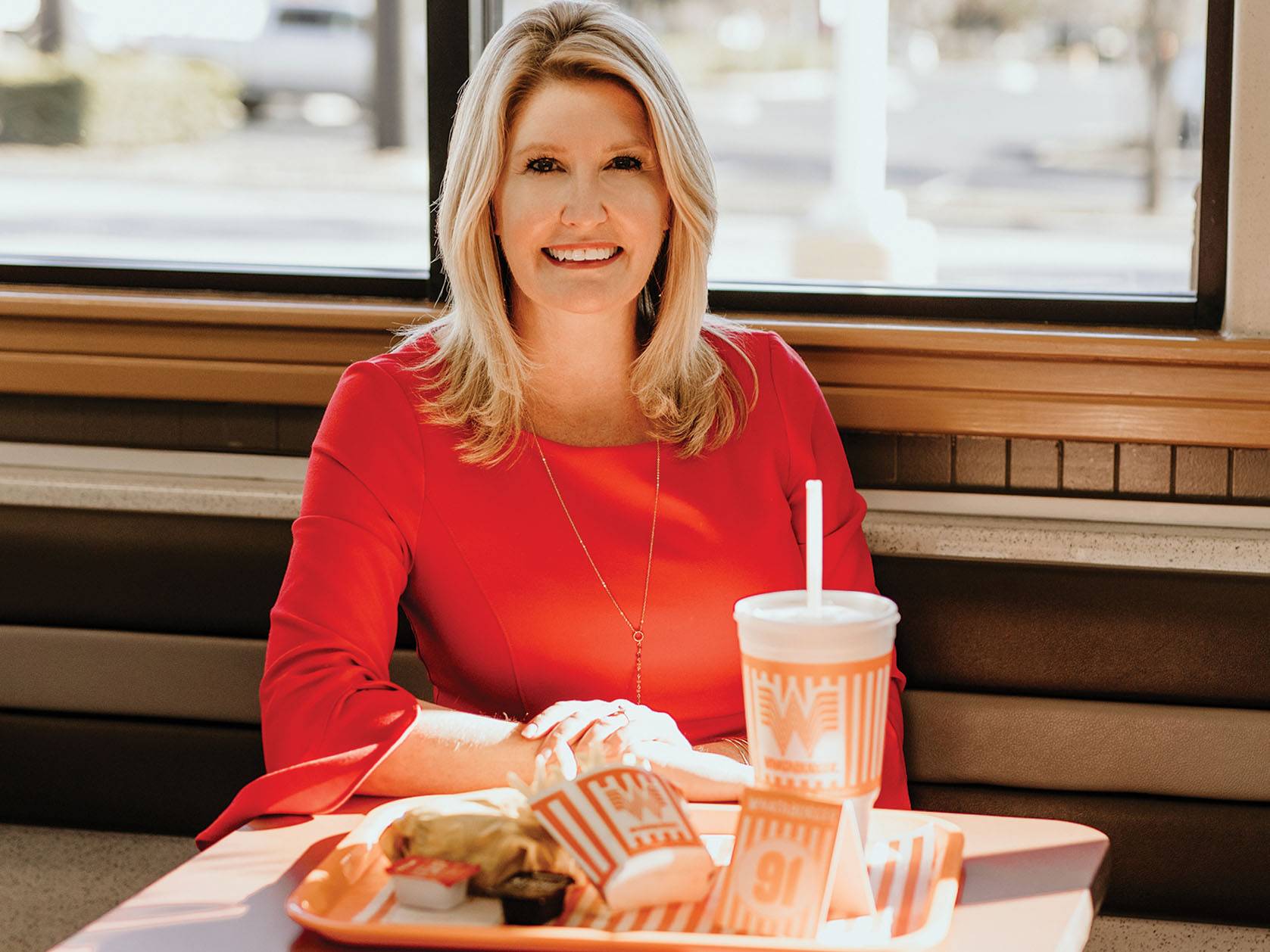 woman in red dress sitting at whataburger booth