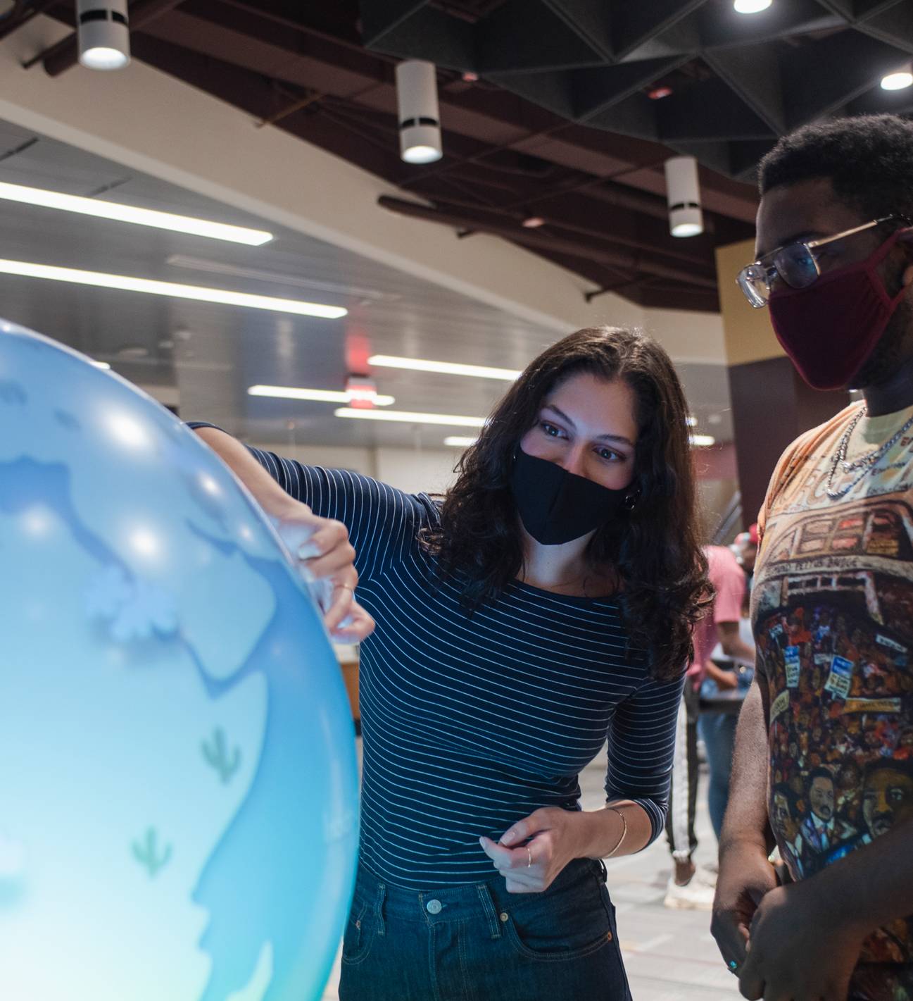 two students looking at illuminated globe