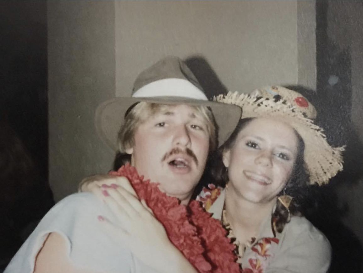 man and woman with hawaiian leis around neck