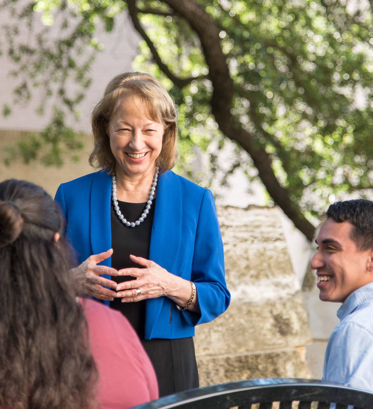 dr trauth standing and smiling at two students