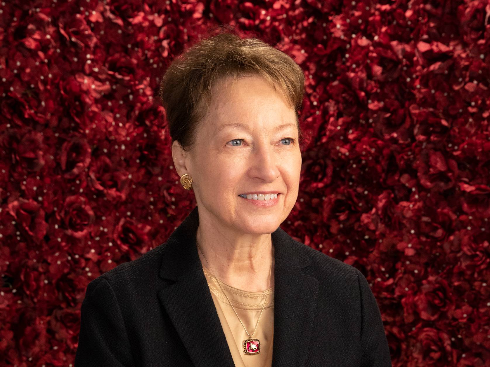 dr trauth smiling in front of red wall