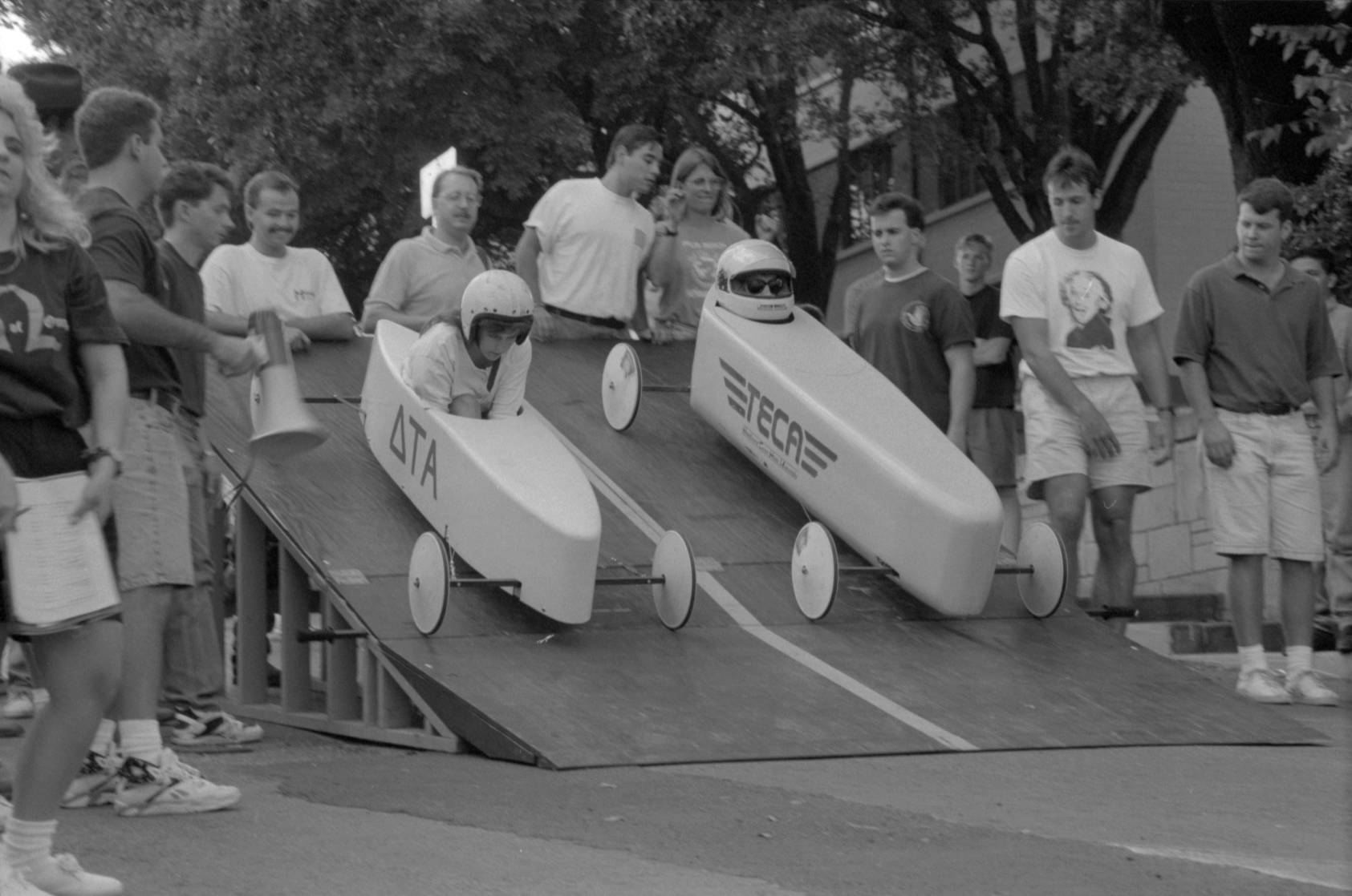black and white photo of soap box derby cars on ramp
