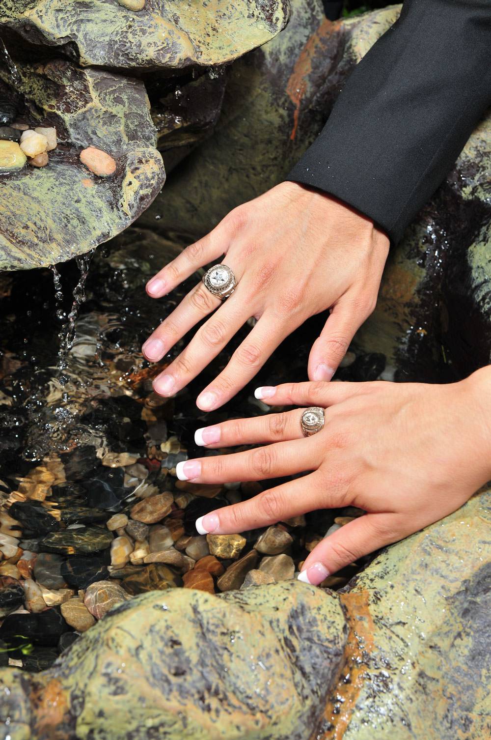 Students dip their new TXST ring into a fountain filled with water from the San Marcos River.