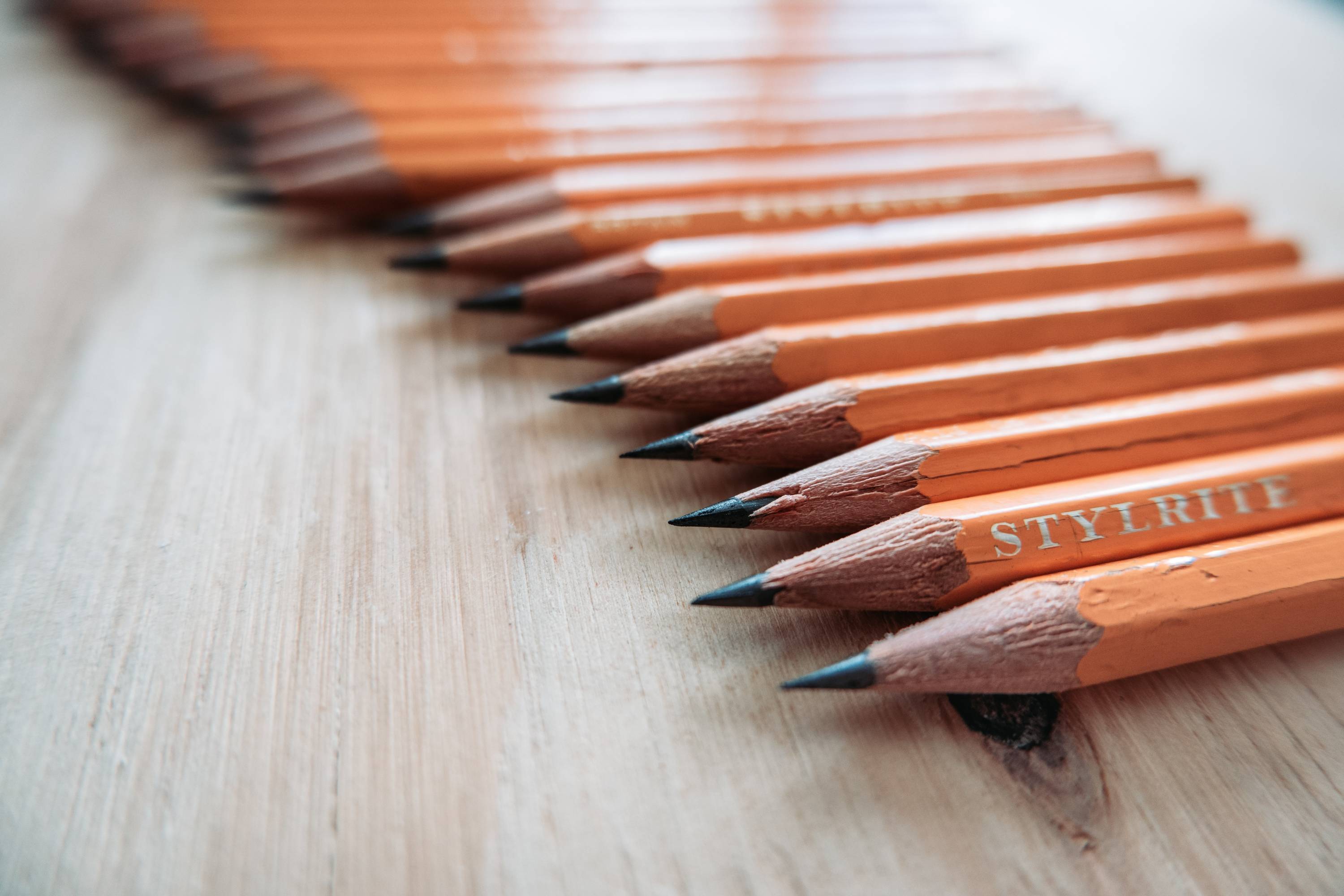 pencils lined up on a wooden table