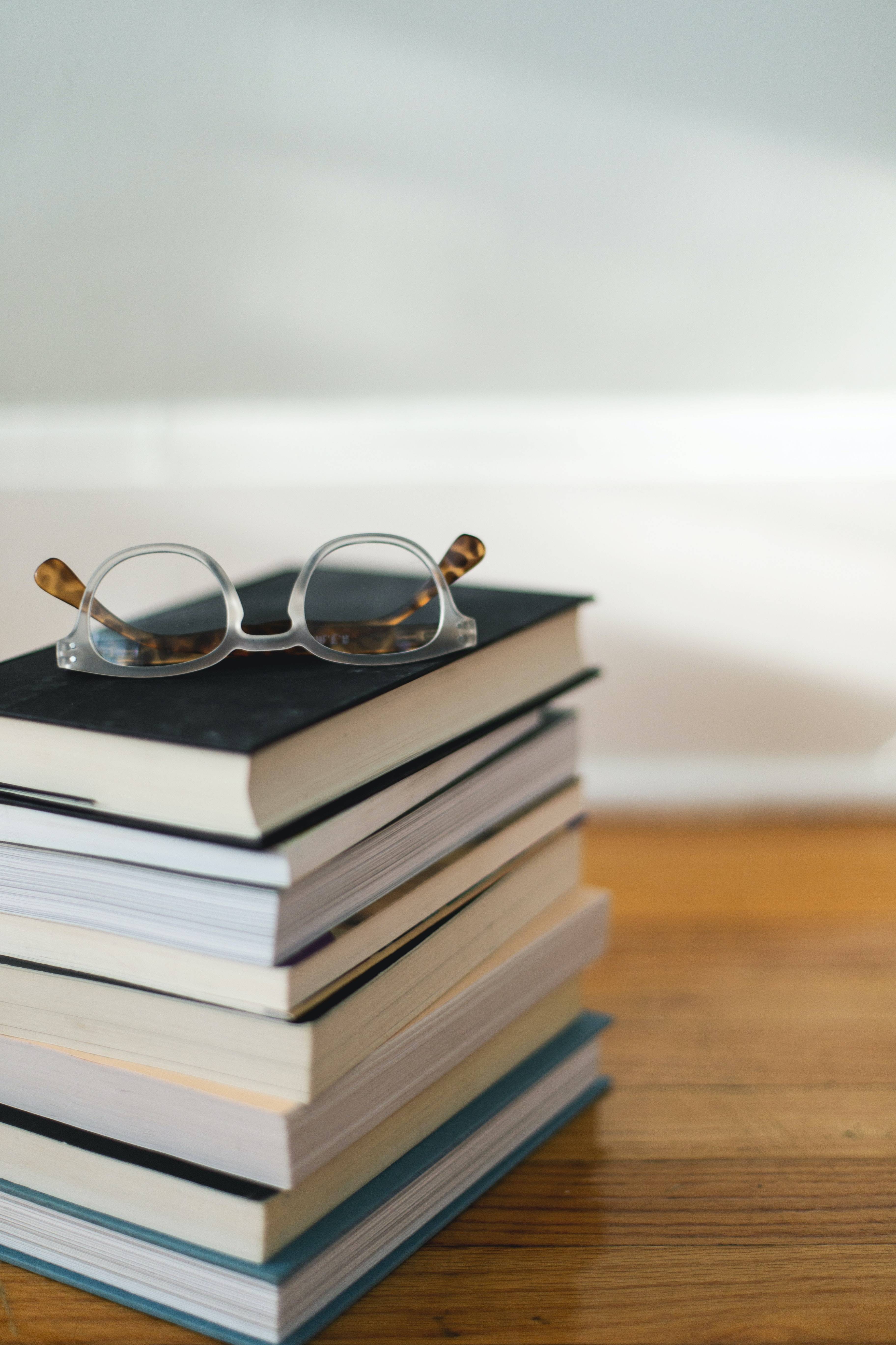 reading glasses on top of a stack of books
