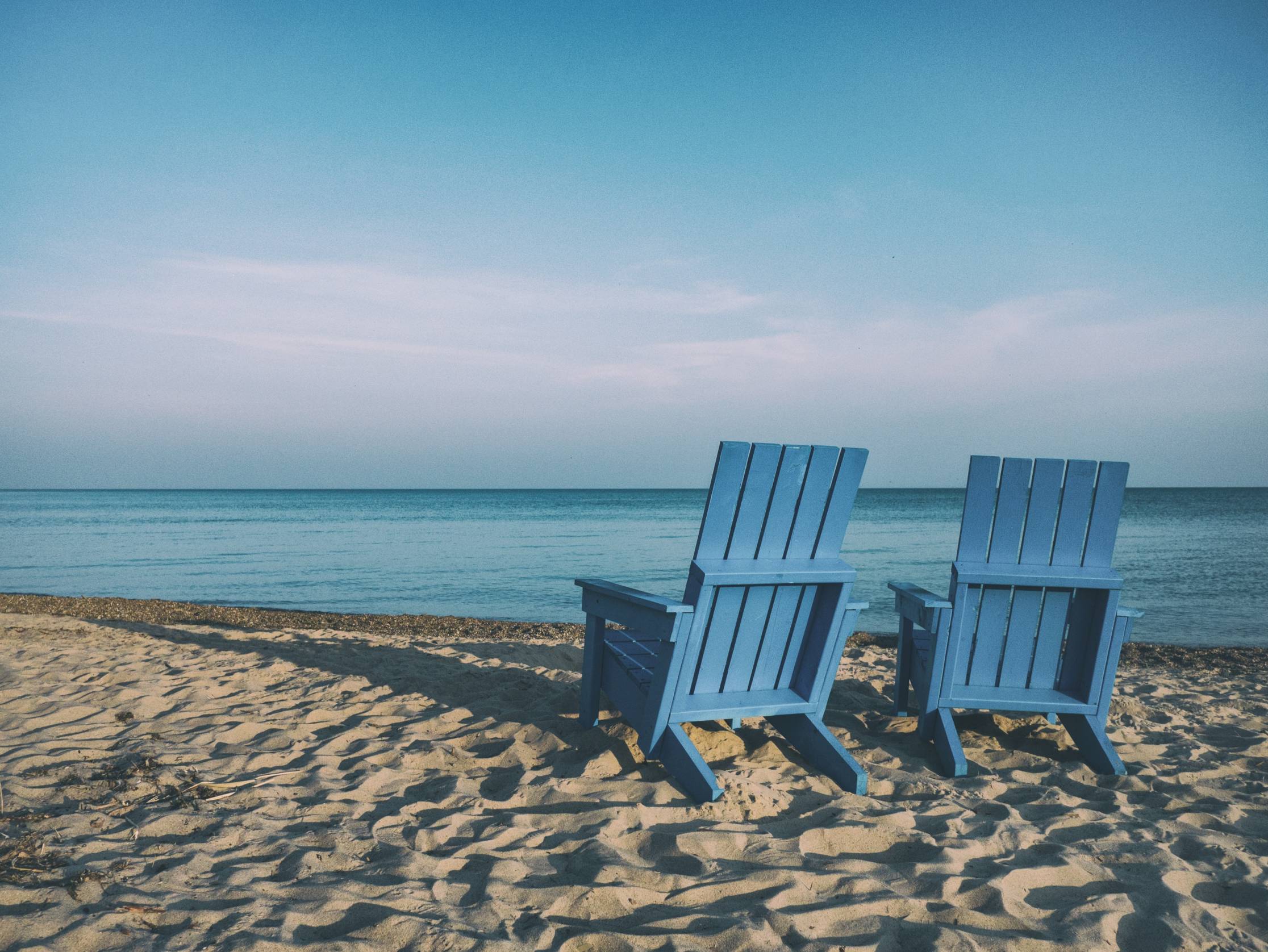 beach with two blue chairs