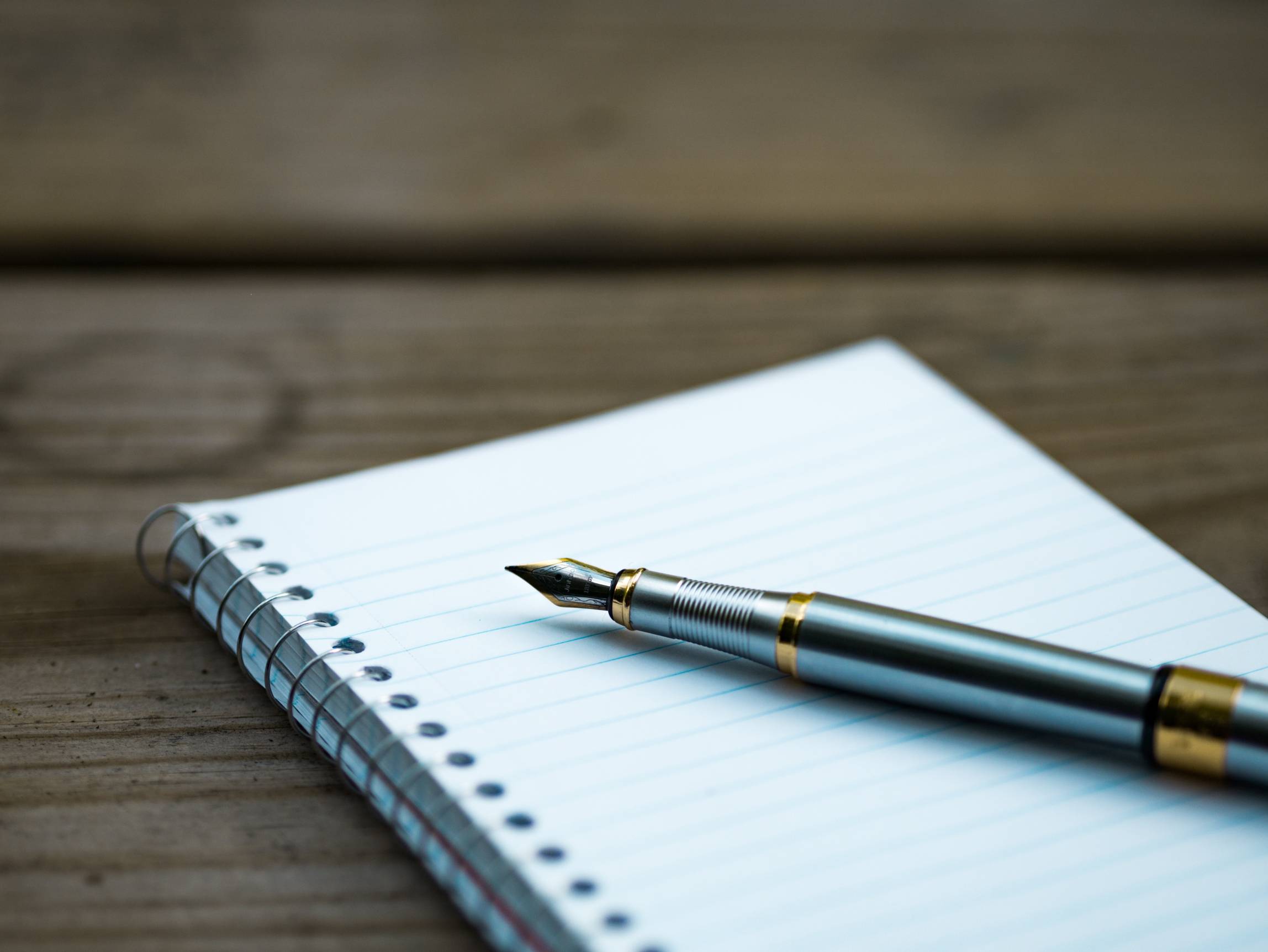 a pen sitting on a blank notepad