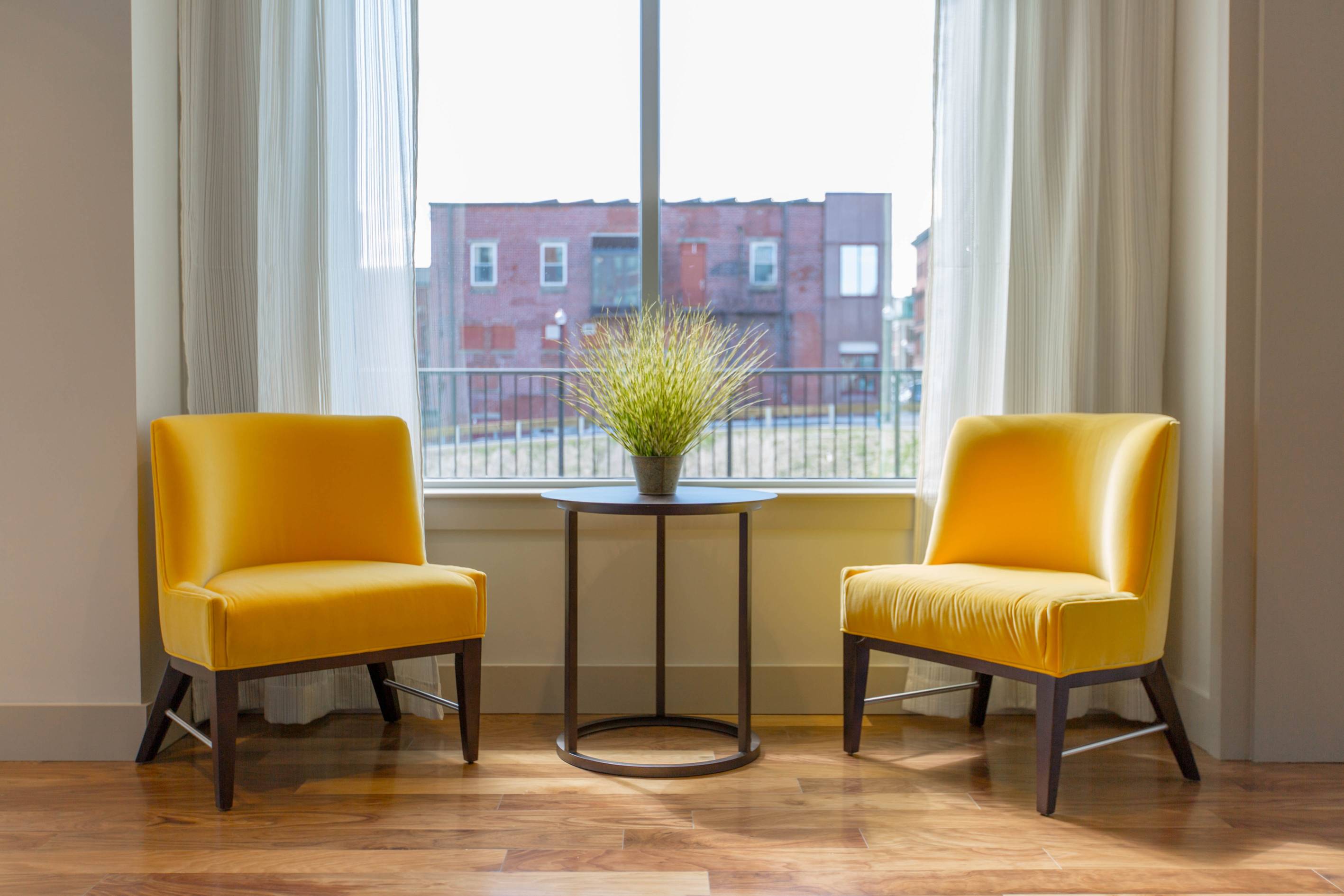 Two yellow chairs in front of window
