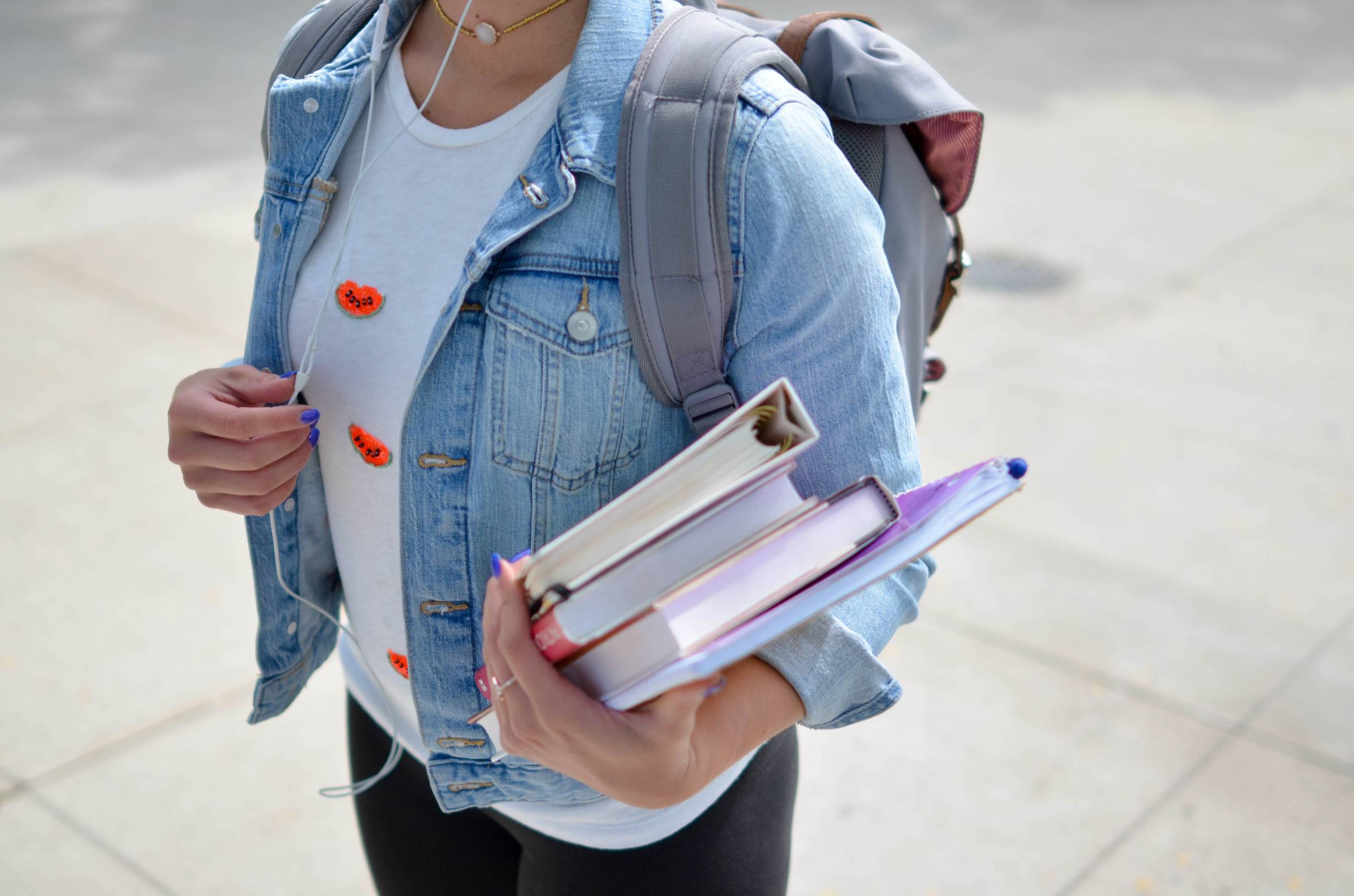 college student walking while carrying books