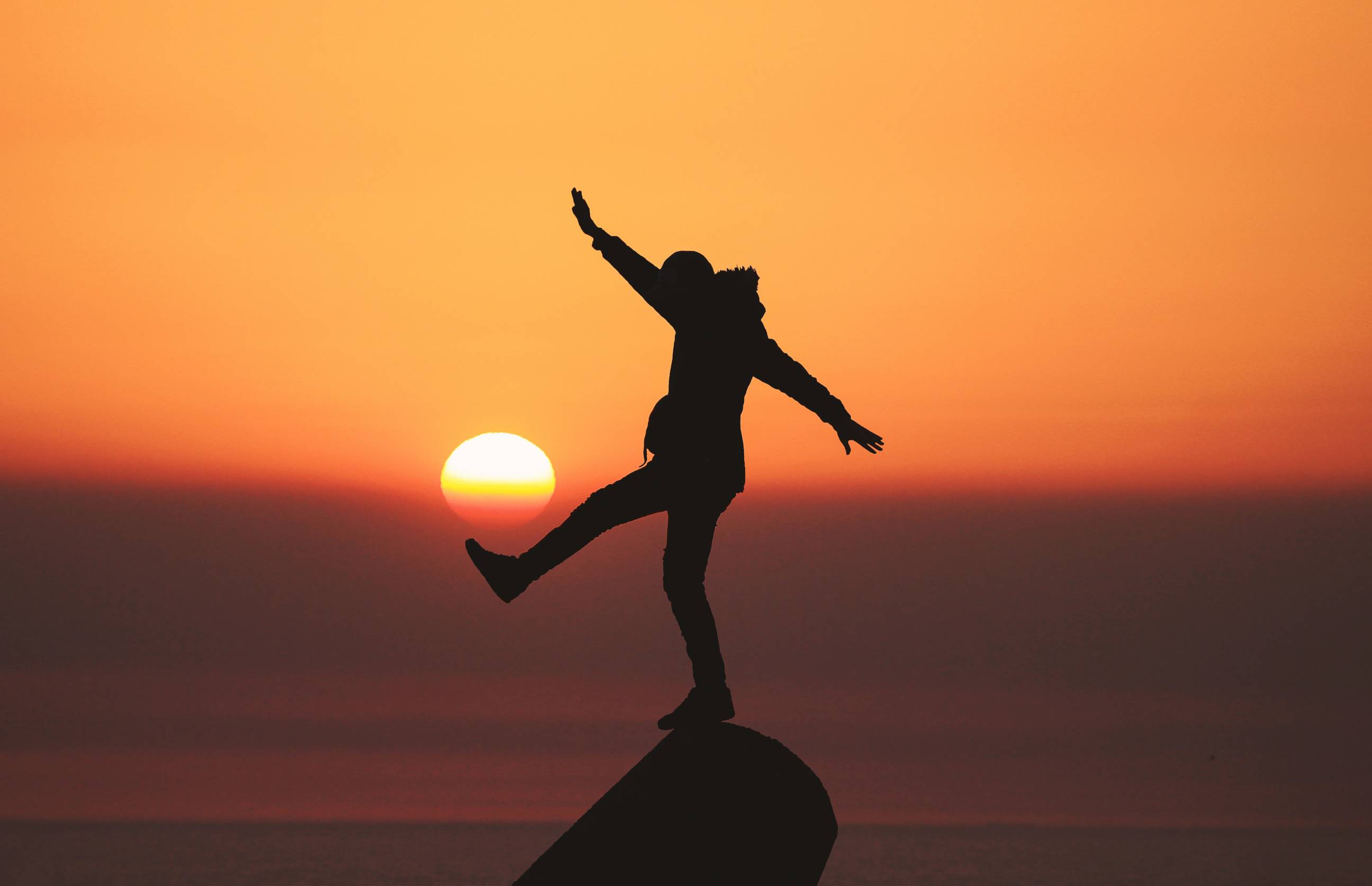 person standing on a rock in the sunset