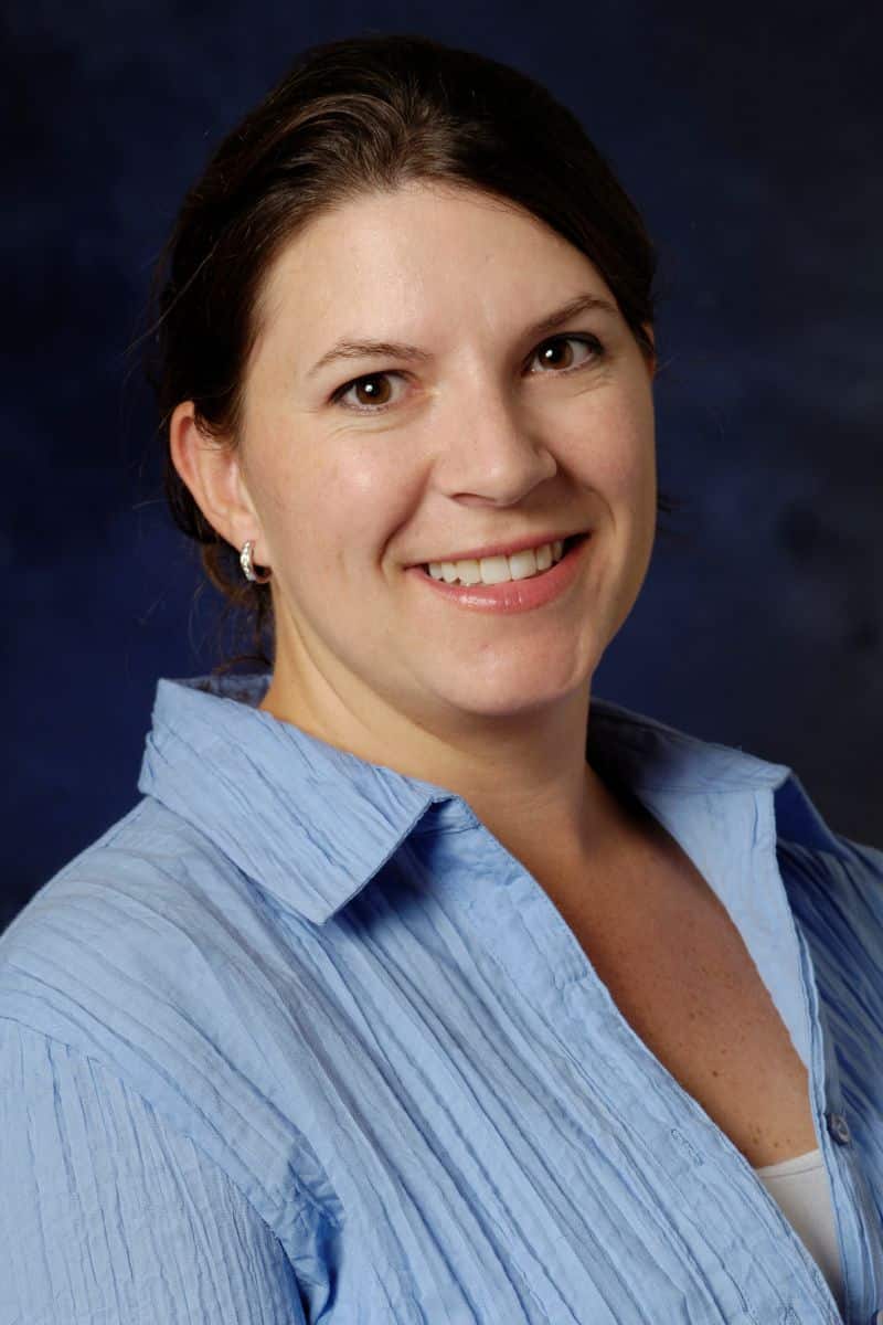 Photograph of Dr. Amanda Elam with brown hair and a blue button down shirt