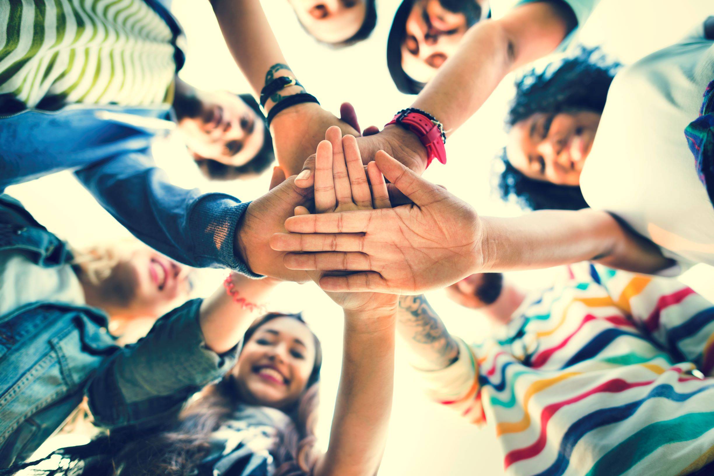 college students stacking hands in teamwork 