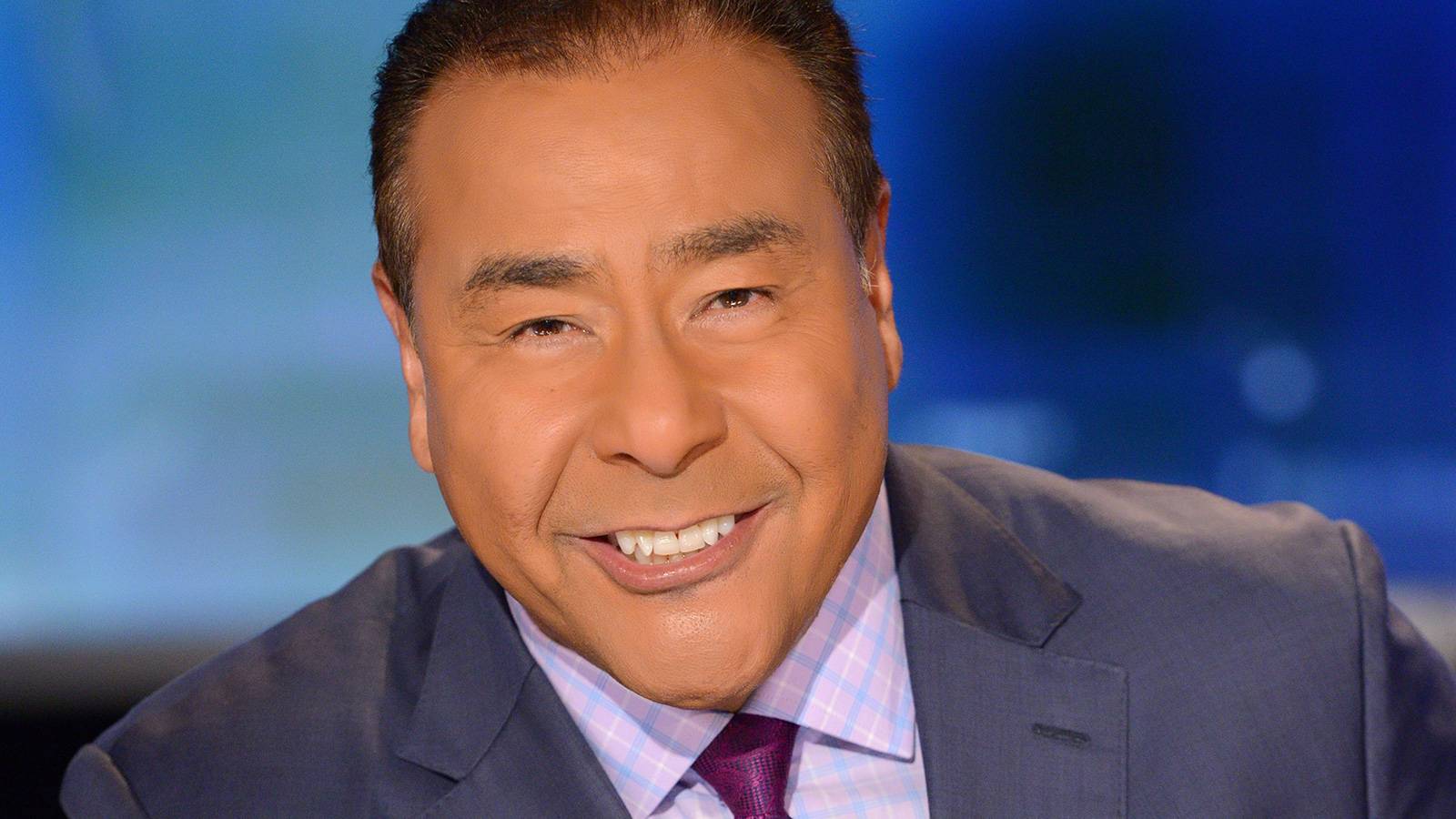 John Quiñones smiling on a TV news set