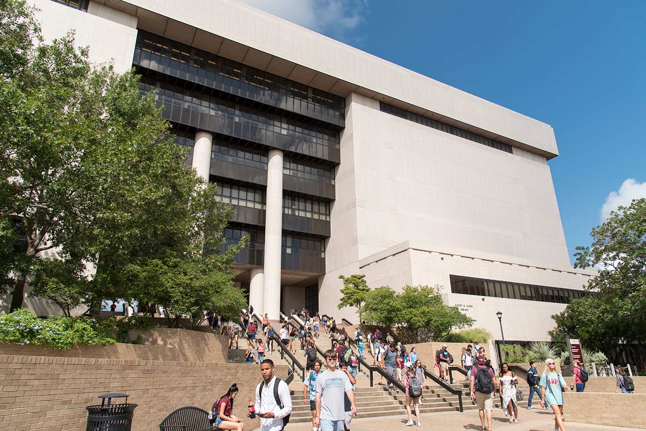 exterior view of the alkek library with students walking down stairs