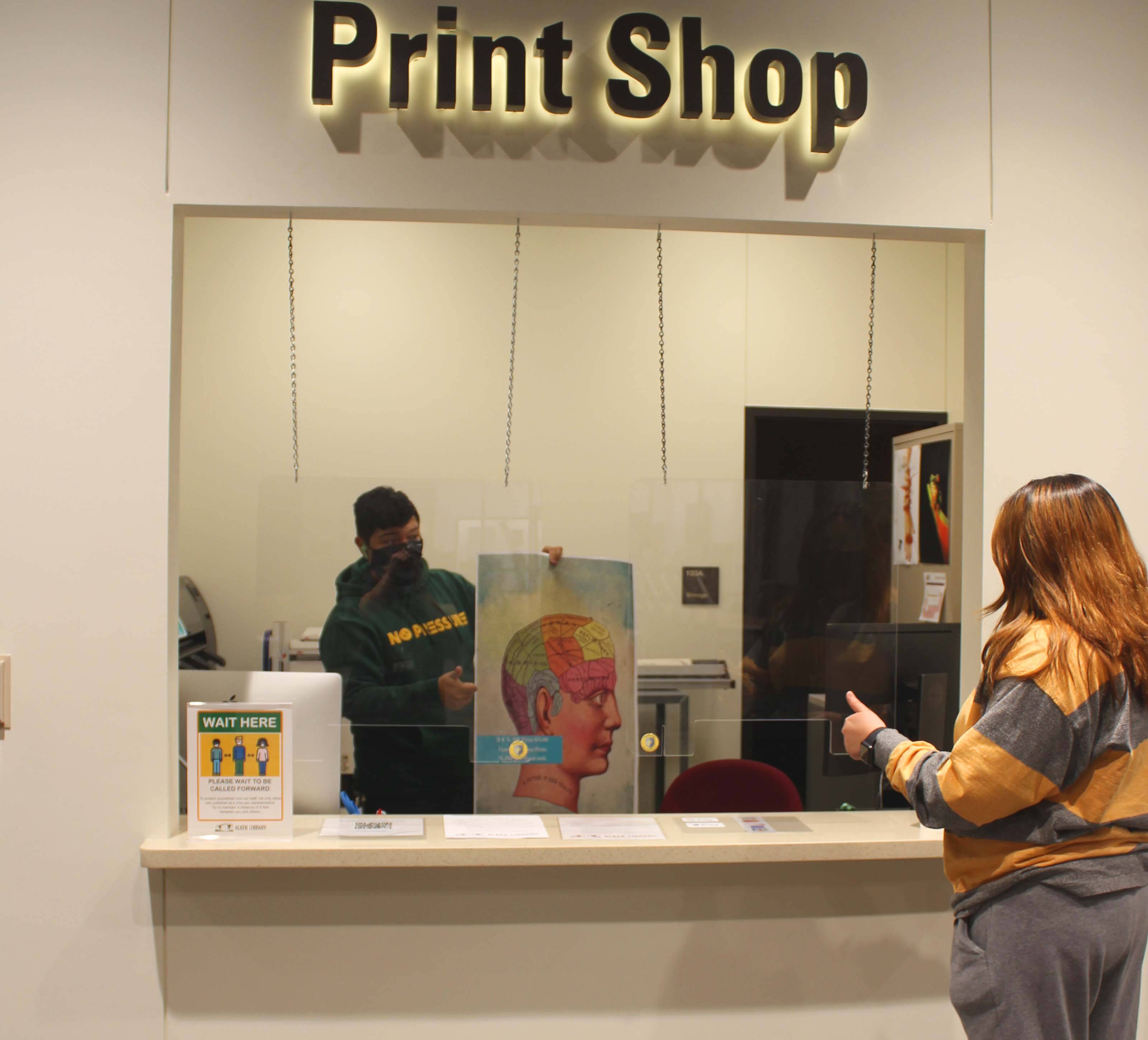 Customer reviewing poster at print shop window