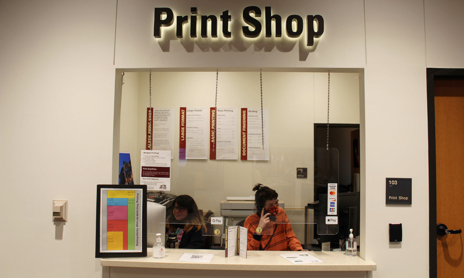 Customer reviewing poster at print shop window