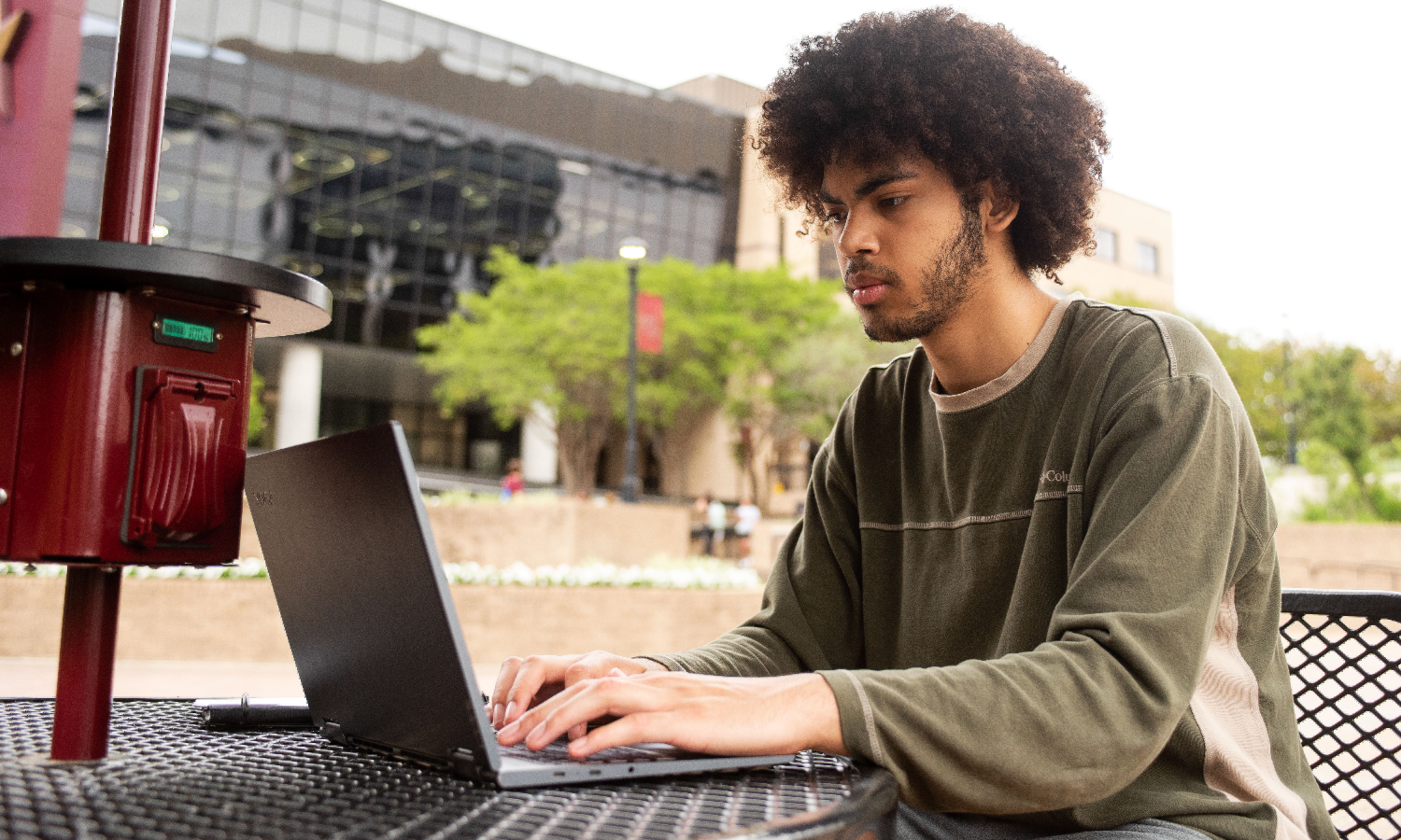 student on computer outside