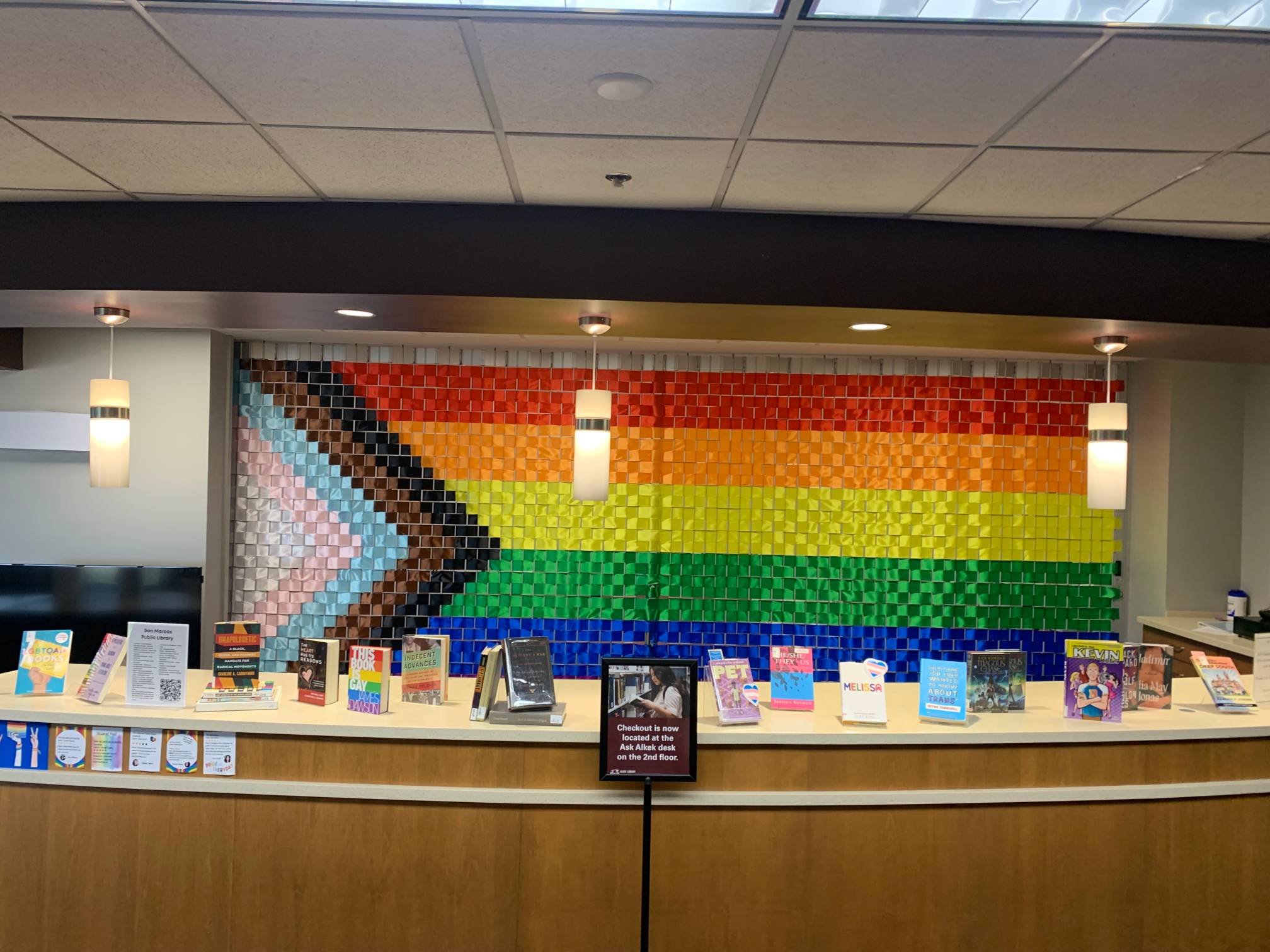 Pride flag with books related to LBGTQ topics