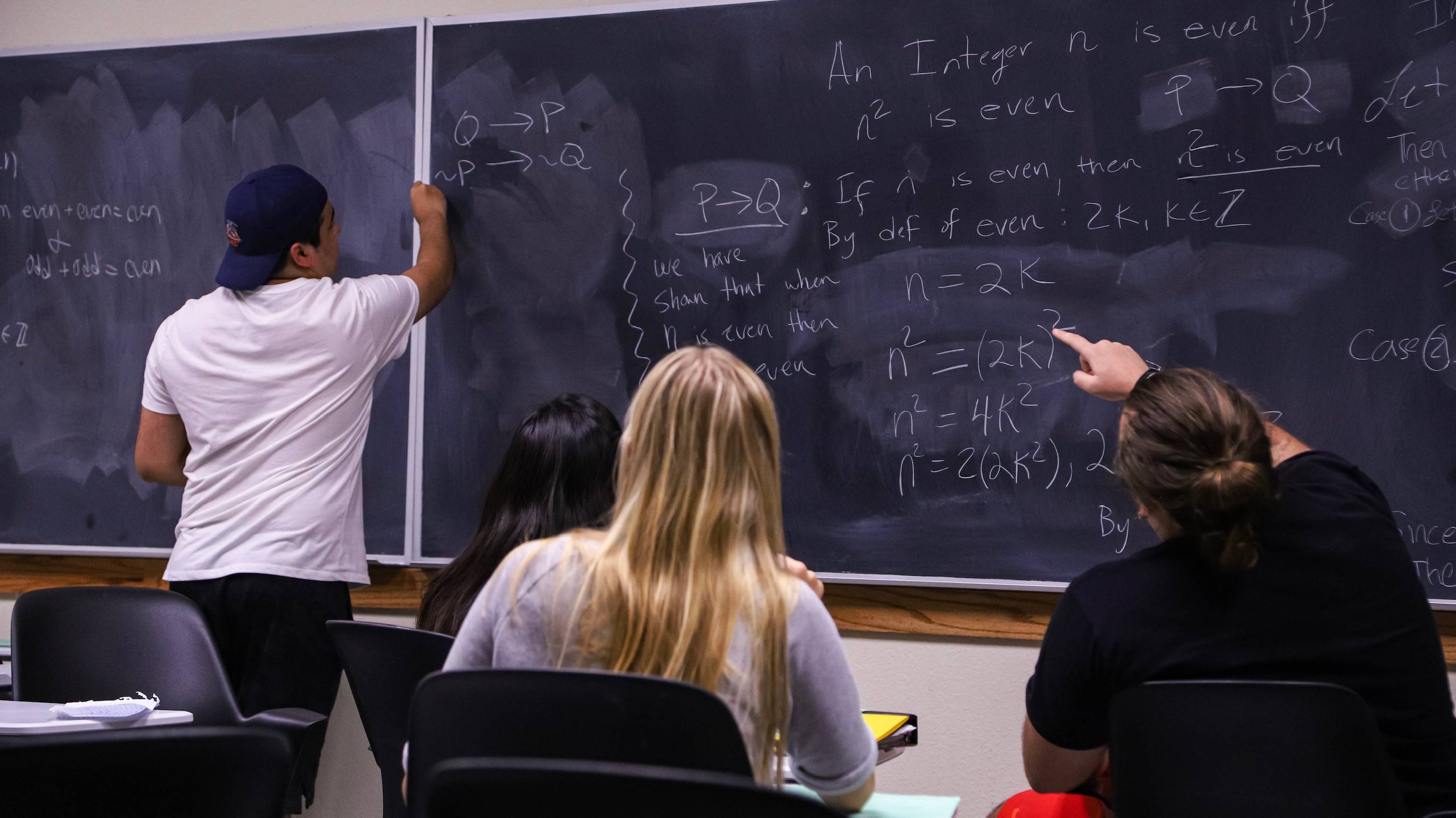 student solving problems at a blackboard