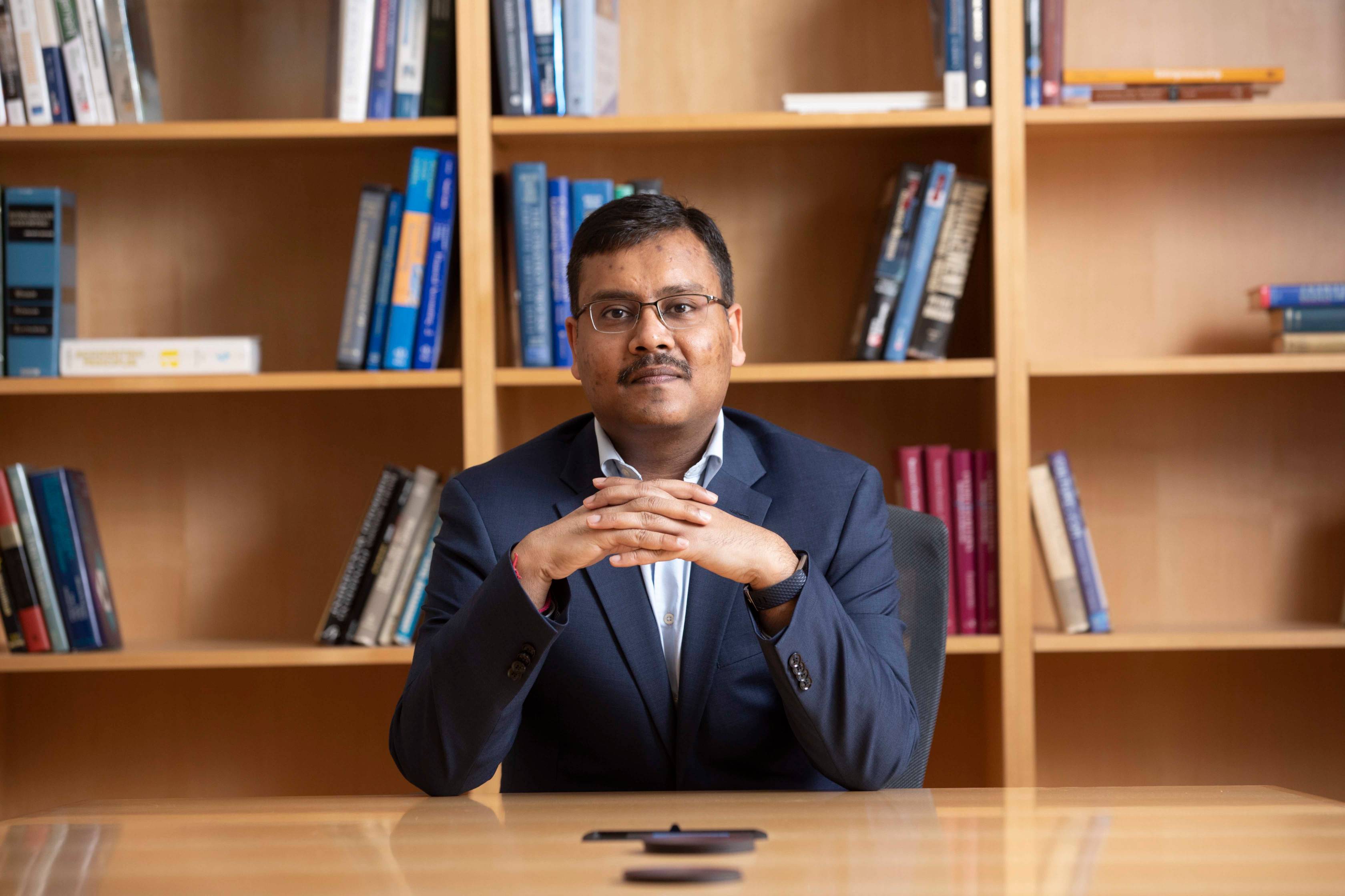 Dr. Gupta sitting in front of a bookcase