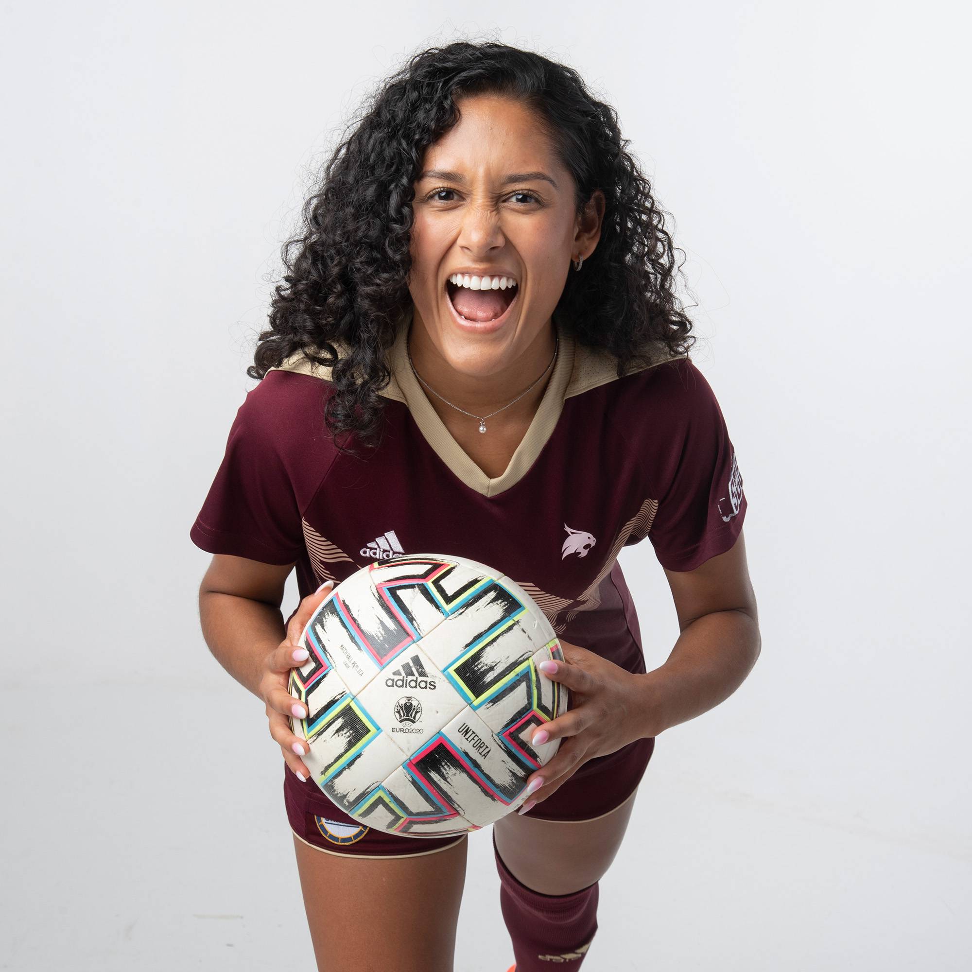 Juana Plata showing fierce facial expression and holding a soccer ball