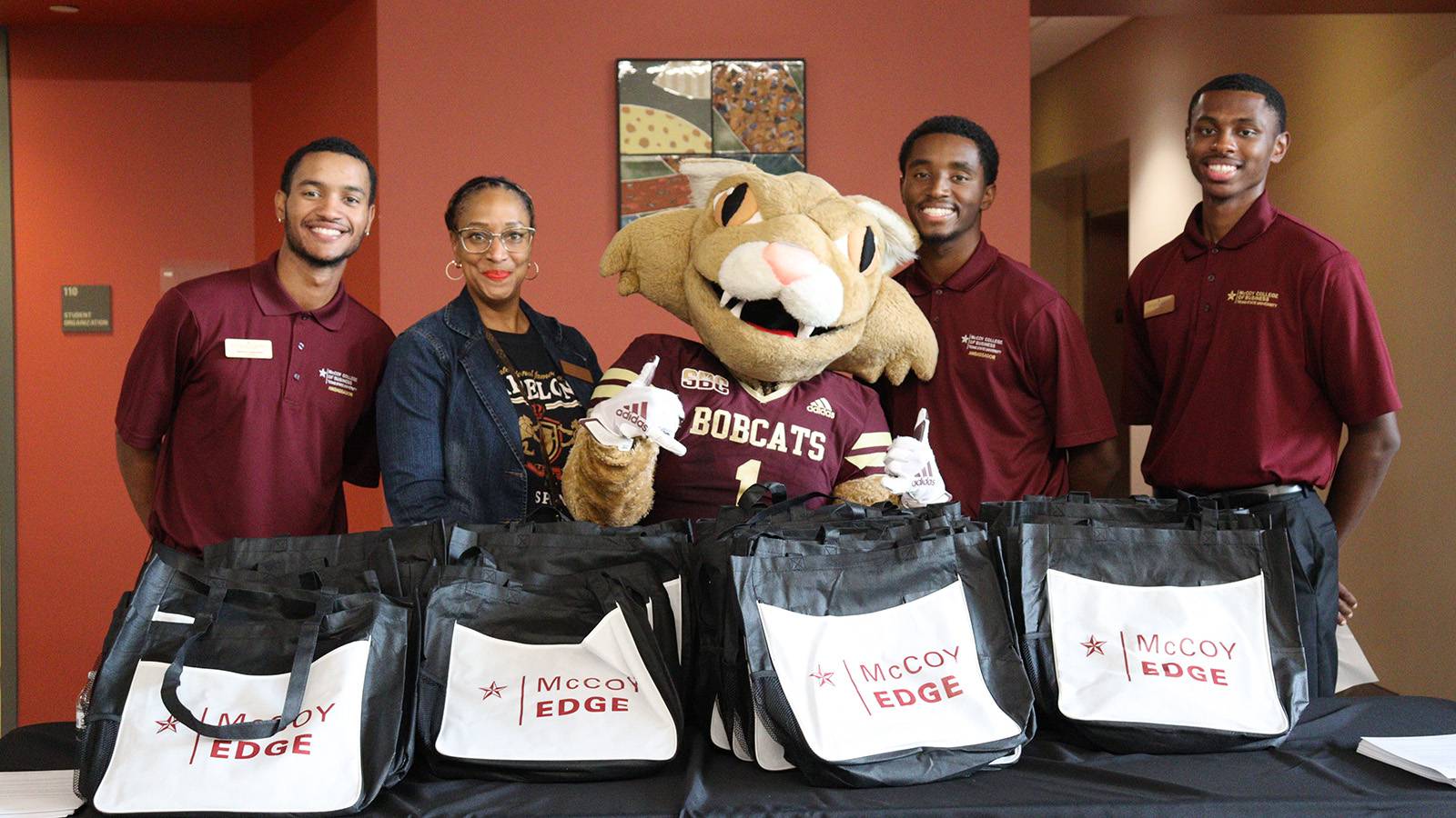 Three McCoy Ambassadors with professor and Boko mascot at the welcome celebration